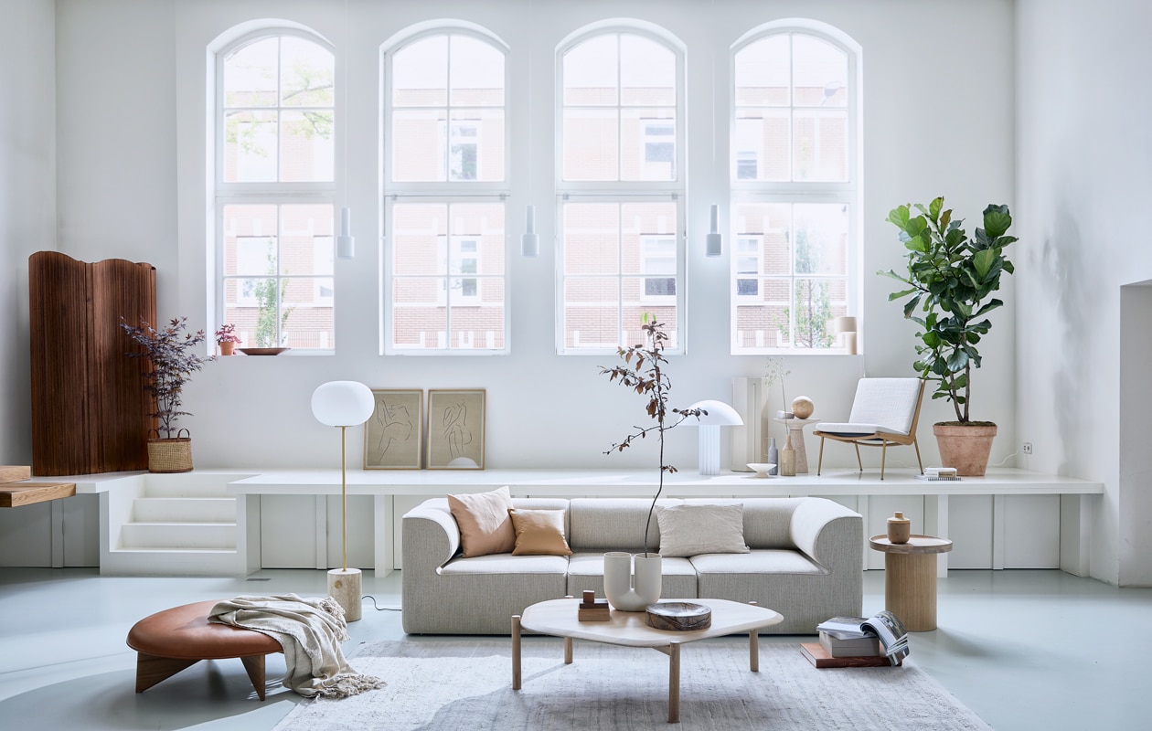 Elementenbank Eave van Menu space hoek element vanaf 86×70,5x86cmlxhxb€ 1822,- en midden element vanaf 86×70,5x75cm lxhxb € 1366,-, vloerlamp jwda van Menu € 1499,95 (designtales.nl). Vloerkleed (misterdesign.nl). Bijzettafel plateau in witgekalkt gelakt eiken 52,3x48x48cm hxbxl € 439,-, salontafel Island in wit geolied eiken 35x129x107cm hxbxl € 999,-, leren kussen classic 40x40cm € 272,- (bolia.com). Leren ronde poef van Fogia € 1635 diameter 112cm, fauteuil Boomerang van &amp;tradition 69x80x61x42cm lxhxbxzh € 2472,- (kasstoor.nl). Witte u vormige vaas kink van Muuto € 179,- (homestede.nl). Vintage kamerscherm € 1250,- (neeflouis.nl). Zuiver Victoria bijzettafel € 279,-, HKliving Cupola tafellamp € 395,-, marmeren Ferm Living Scapa schaal € 179,-, nude HKliving fruitschaal € 29,-, Madam Stoltz vaas in zand op podium € 34,50, vtwonen langwerperige vaas met handvat in grijs € 34,95 (vtwonen.nl). Stukjes hout (fijnhout.nl). Mand € 39,95 (hm.com). Pilaar € 50,- (com-anders.nl). Posters Grace 1 en Grace 11 by lemon 50x70cm met ijken frame € 90,- (papercollective.com). Zalmkleurige kussenhoes 50x50cm € 9,99 (zarahome.com), linnen kussen 60x40cm € 59,- (bymolle.com). Overig privébezit. vtwonen 08-2020