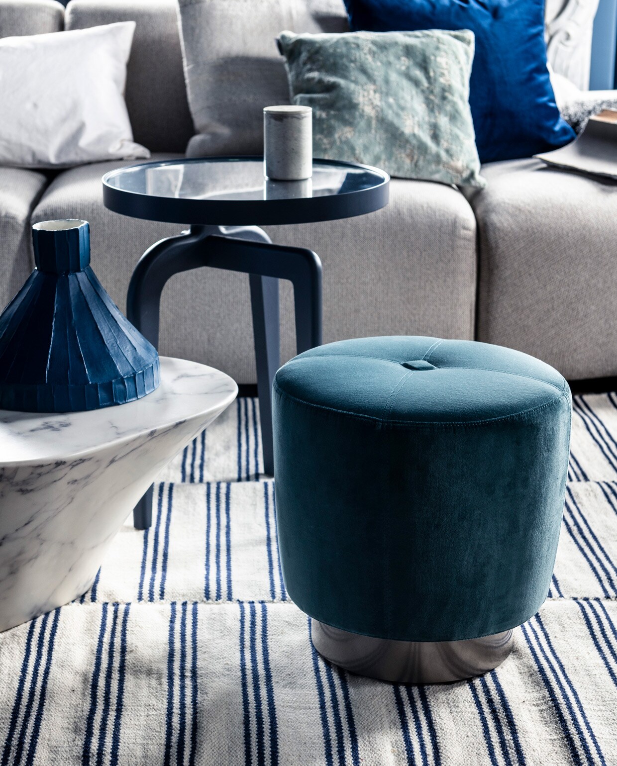 Bank Jax hkliving.nl, element vanaf € 499,- (vtwonen.nl). Kleed € 199,- (zarahome.com). Marmeren salontafel € 587,50 (polspotten.nl). Blauwe salontafel Schönbuch € 719,-, wit kussen Mrs.me € 99,- (homestede.nl). Blauw kussen € 49,-, ecru kussen € 49,- (couleurlocale.eu). Blauwe vaas, smal toelopend € 469,- (badenbaden.nl).