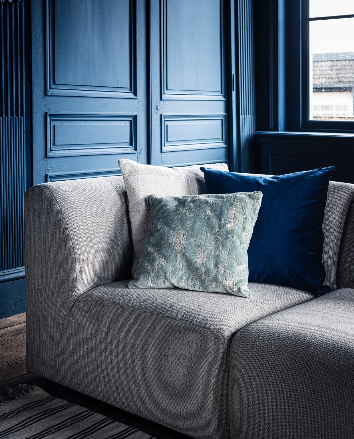 Bank Jax hkliving.nl, element vanaf € 499,- (vtwonen.nl). Kleed € 199,- (zarahome.com). Wit kussen Mrs.me € 99,- (homestede.nl). Blauw kussen € 49,-(couleurlocale.eu). Kussen Sarona vintage blue 45×45 cm € 35,- (polspotten.nl). vtwonen 07-2020