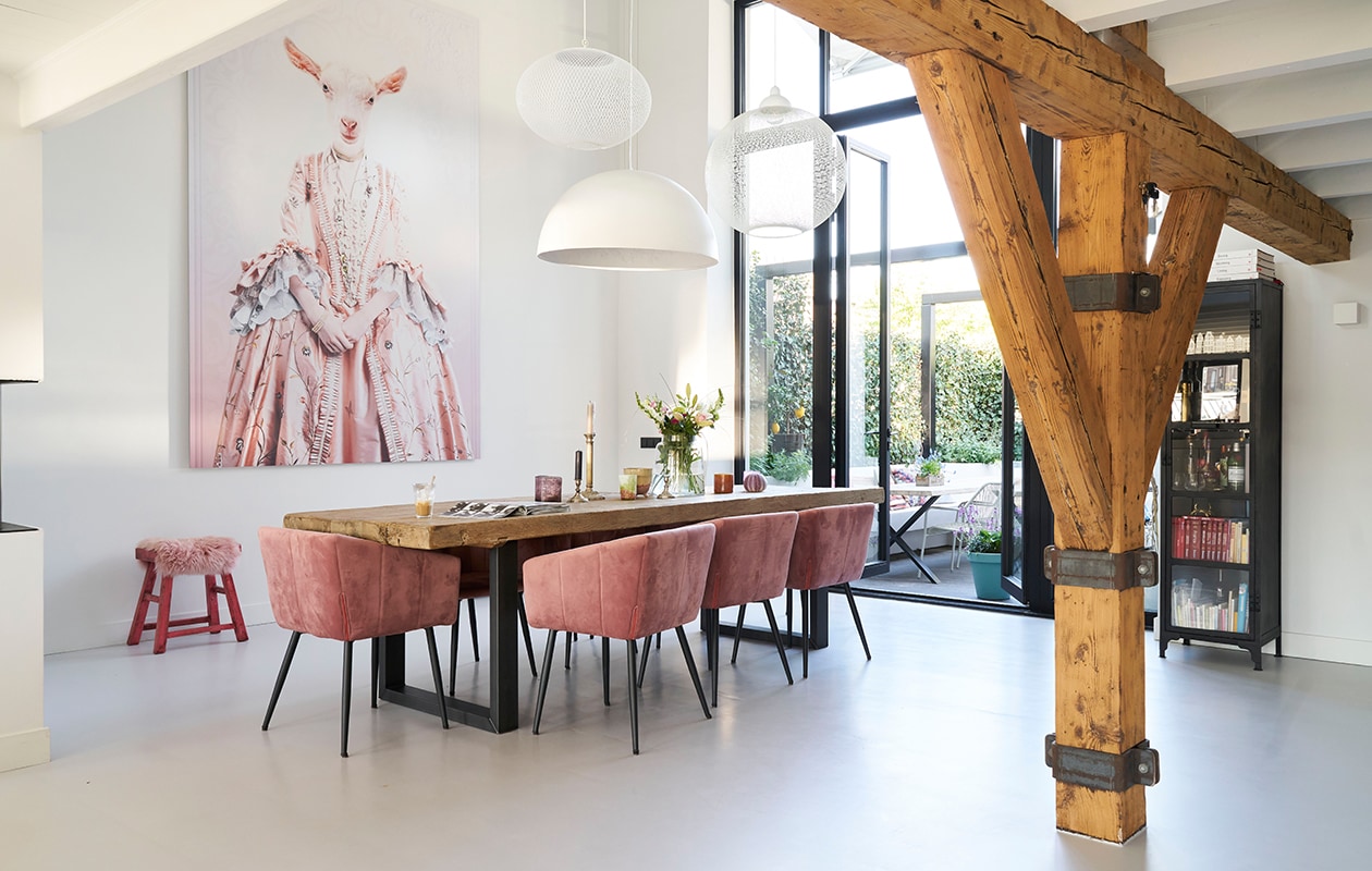 Eettafel eigen ontwerp en op maat gemaakt. Fluwelen stoelen Liv van Kick. Lampen (v.l.n.r.): NR2 van Moooi, Sky Garden van Flos, Non Random van Moooi. Fotocollage Mondi Art Shop. Kruk De Pagter Interieurs. Vintage kandelaars, keramiek en glaswerk in de loop der jaren verzameld. vtwonen 08-2020 | productie Features &amp; more | styling Wilma Custers | fotografie Luuk Geertsen