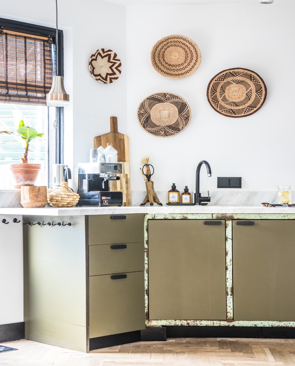 Keuken gemaakt vanoude werkbank. Apparatuuren kraan Keukenloods.Keukenfronten Keyser Craft.Stalen grepen Ikea.Marmeren keukenbladBig Stone. Vitrinekast enkeukenrek Karwei. Mandengroothandel. Hanglampvintage. PlafondspotsKarwei. vtwonen 07-2020 | binnenkijken Zaandam
