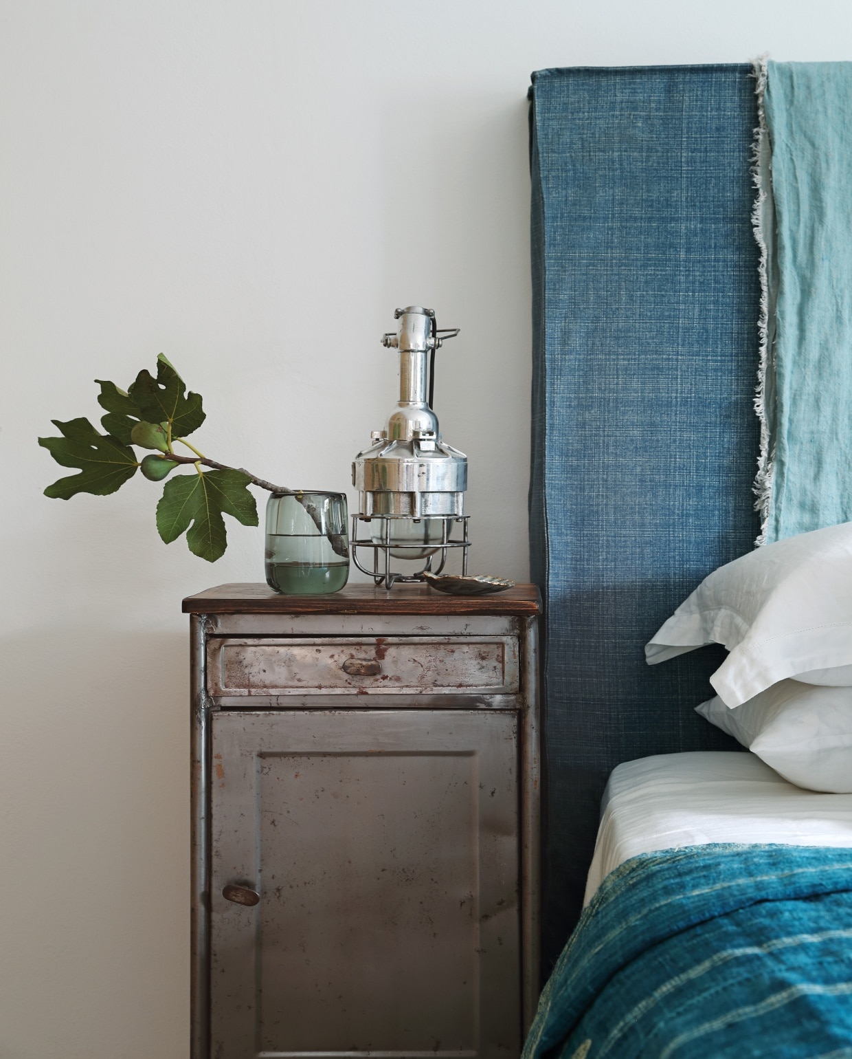 Vintage metalen nachtkastjes van de Parijse vlooienmarkt Clignancourt. Turkooizen bedsprei Hubert Zandberg Interiors, kussens bekleed met stoffen van Fermoie. vtwonen 08-2020 | binnenkijken buitenland ibiza | Fotografie Elsa Young