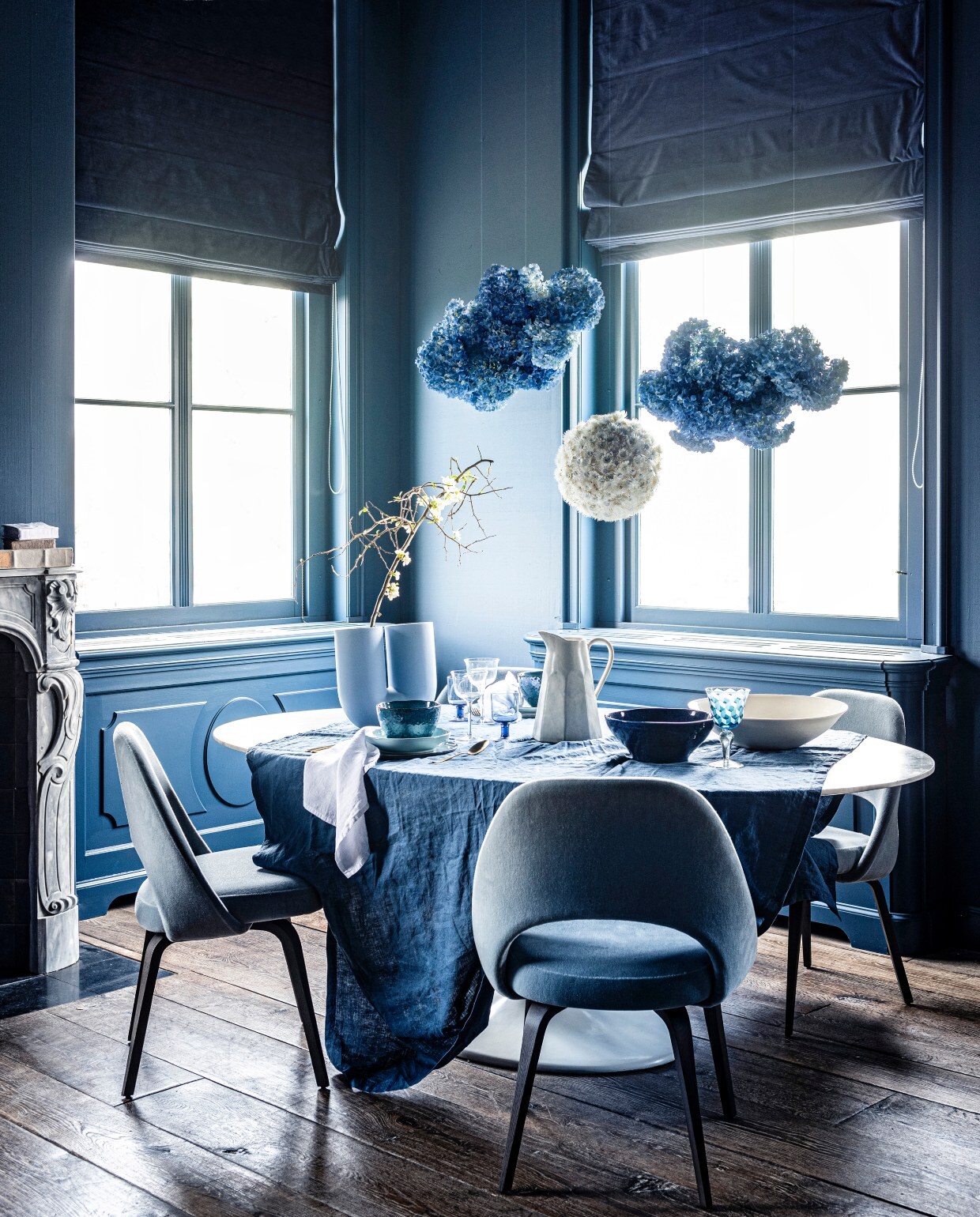 Bloemenpompons prijs op aanvraag(tuinvanjudith.wordpress.com). Veloursstoel vanaf € 1200,- (edha-interieur.nl).Marmeren eettafel, prijs op aanvraag,marmeren schouw Lodewijk XIV € 15.125,-,18e-eeuwse houten vloer, per m²€ 168,19 (pietjonker.nl). Tafelkleed145×250 cm € 39,99, servet per 2 € 9,99,transparant wijnglas € 7,99 (hm.com).Witte schaal, prijs op aanvraag, boekenop schouw € 12,- (badenbaden.nl).Blauwe schaal € 35,99, kan € 35,99(zarahome.com). Blauw glas met print,set van 6 € 129,- (polspotten.nl).Gordijnstof 295 cm breed, per meter€ 103,- (wva.nl). Onderbord vanLeonardo, Ø 27 cm € 12,95, bord vanLeonardo, Ø 23 cm € 9,95, kom vanLeonardo, Ø 15 cm € 9,95, goudenbestekset van Amefa, 24-delig € 57,95(vtwonen.nl). Vaas van Muuto € 179,-(homestede.nl). Blauw wijnglas € 8,95(loods5.nl). Takken en bloemen prijsop aanvraag (greenlifestylestore.nl).Overig privébezit. vtwonen 07-2020 | styling blauw