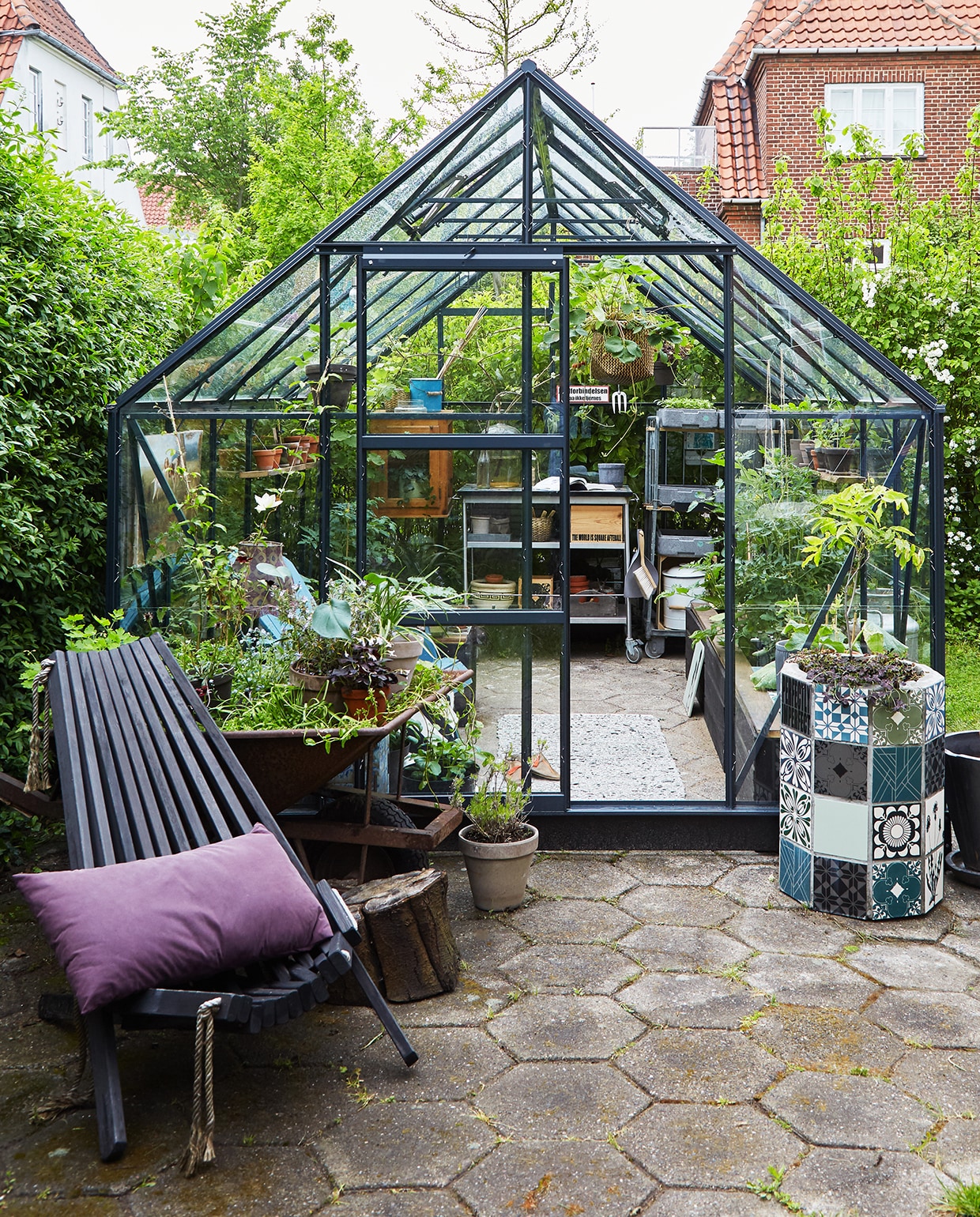 Voor doorgewinterde tuiniers is een tuinkas de hemel op aarde. Hij is zo gebouwd dat hij bij het minste zonnetje al goed opwarmt, waardoor je heel vroeg in het jaar bloemen, fruit en groenten kunt zaaien, telen en stekken. Ook kun je planten die niet vorstbestendig zijn hier laten overwinteren. Planten die in de kas zijn opgekweekt, kunnen in de lente naar buiten, waar het dan inmiddels warm genoeg voor ze is. Eigenlijk verschuif je met een kas de seizoenen. Maar ook voor de wat minder geroutineerde tuiniers is een kas een aanwinst: zodra de zon zich even laat zien kun je de tuin in en zit je warm tussen het glas. Op zoek naar een kas? Kijk bijvoorbeeld op boerenbond.nl, tuinexpress.nl of tuinadvies.nl. vtwonen tuin special 1 | buitenplaats met donker glazen kas Kopenhagen