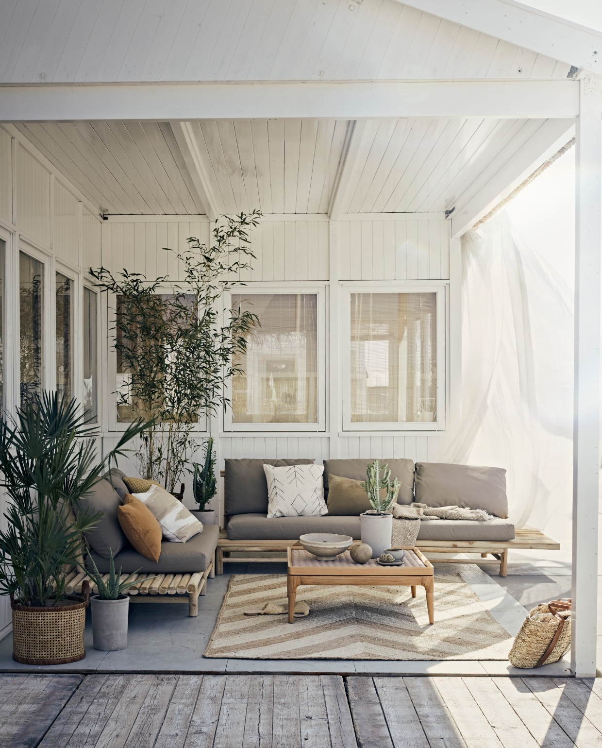 Buitenloungebank Twiggy van Applebee, 3-zits rechts € 725,-, 2-zits lounge-element links € 505,-, Twiggy lounge hoektafel € 309,-, afmeting set 329x261x70 cm (lxbxh) (fonteyn.nl). Juten vloerkleed van Madam Stoltz, 150×245 cm € 295,- , planten met pot van vtwonen vanaf € 25,90 (vtwonen.nl). Okergeel geruit kussen € 28,95, wit kussen met zwart borduursel € 53,-, grijs schaaltje € 11,-, kom € 6,95 (madamstoltz.dk). Rotan manden € 39,99, wit met beige kussenhoes € 19,99 (hm.com). Papier-maché schaal € 38,40 (nordal.eu). Linnen kussen in karamel en kaki, 60×40 cm, katoenen plaid € 23,95 (iblaursen.nl). Salontafel met gevlochten blad Lima van Gloster, 81x81x31cm (lxbxh) € 2400,- (dacks.nl). Overig privébezit. vtwonen styling 06-2020 strand ajuma