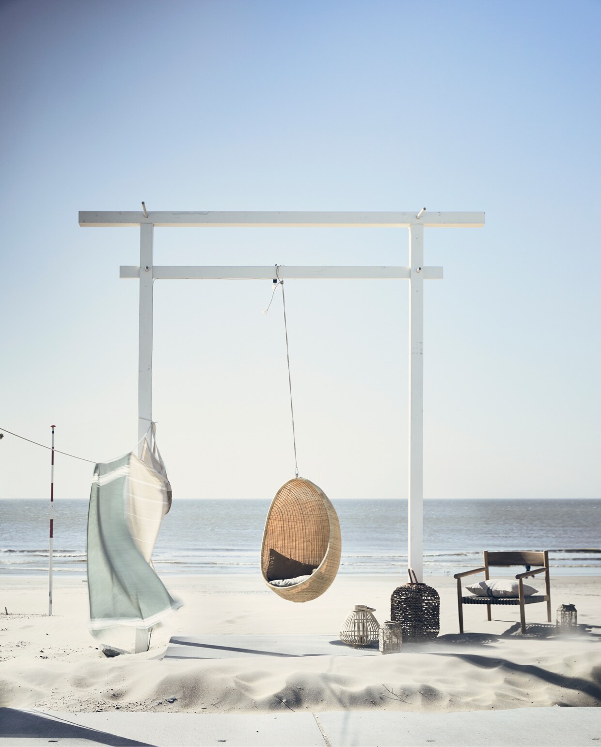 Hangei van Sika-Design 125x85x75 cm (lxbxd) (brechtmurreatelier.nl). Houten lounge chair Tibbo (dacks.nl). Rieten lantaarn xl, wit linnen kussen, groen kussen, groen-witte hamamdoek, naturel handdoek(madamstoltz.dk). Kleine rieten lantaarn (hm.com). Bamboe lantaarn Sara van Broste Copenhagen (vtwonen.nl). Overig privébezit. vtwonen 06-2020 | strand ajuma | Fotografie Jeroen van der Spek | Styling Cleo Scheulderman