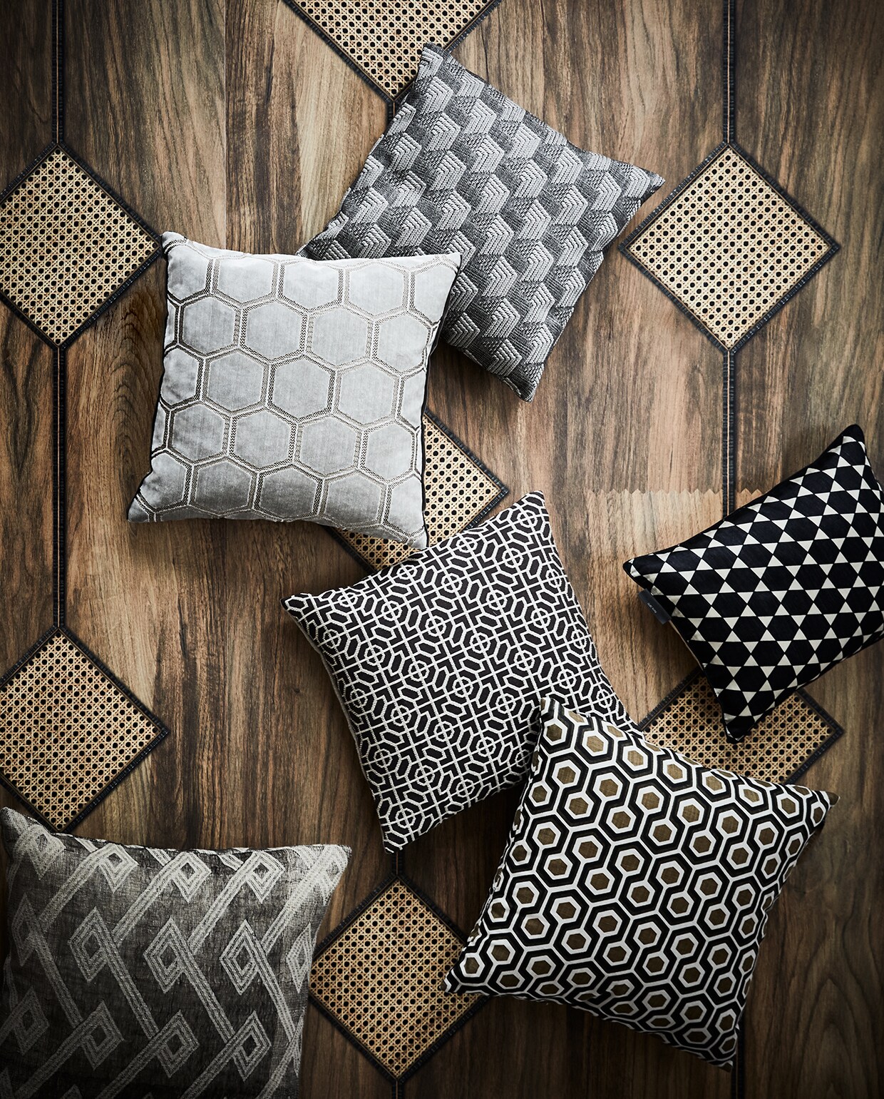 Fotobehang MRV-17 Diamond Webbing van Mr. &amp; Mrs. Vintage in kleur Mahogany, 48,7 cm breed (nlxl.eu). Kussens, van bovenaf: zeshoeken van Nobilis, lichtgrijze honingraat van Designers Guild, roosterdessin in het midden-, (wva.nl), zijde met Marokkaanse sterren van Le Monde Sauvage. Kussen met de beroemde ineenhakende zeshoeken van David Hicks (loods5.nl). Linnen met wybers (barbaraemmy.com).