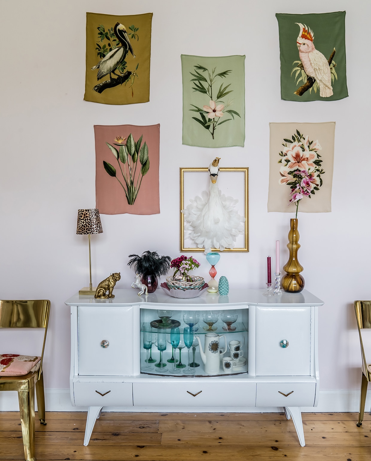 Het witte dressoir is van de kringloop. De foto’s op de lichtroze geverfde muur zijn van zijde en meegenomen uit Parijs. Zwaan aan de muur van Hilary &amp; Flo.