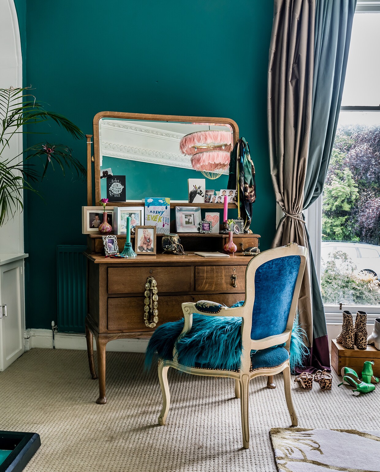 De enorme slaapkamer staat vol massief meubilair. Op de muren: Sea Cove, een rijke groenblauwe verf die het tochtige huis ‘warm’ maakt, aldus Wendy. De kaptafel, een erfstuk van Wendy’s ouders, is een prima huwelijk met een stoel van de kringloop.
