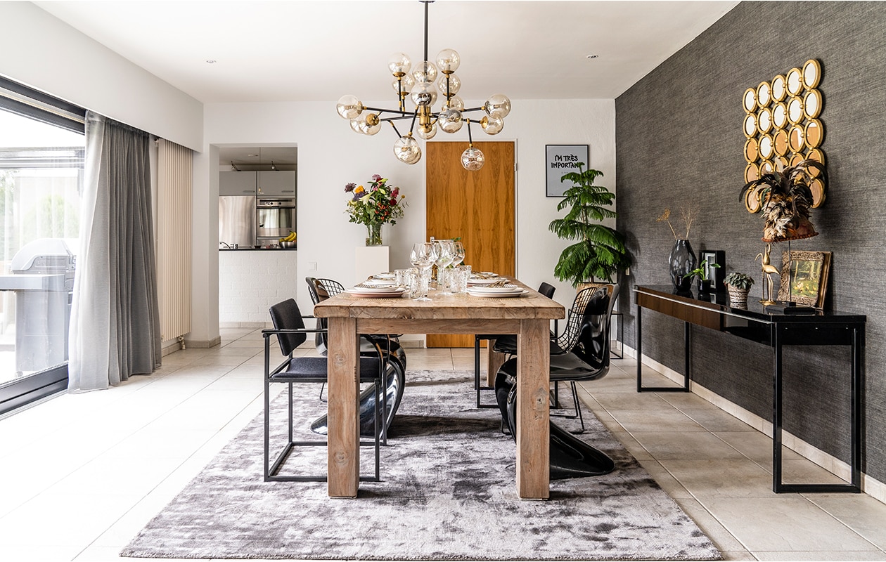 De opvallende lamp komt uit een Parijse boetiek. Michel: ‘Daarna zijn we hem nooit meer tegengekomen.’ Teakhouten tafel Stijl&amp;Co, met vintage Pastoe stoelen, Panton Chairs van Vitra en Bertoia stoel van Knoll. Vloerkleed Ebru.