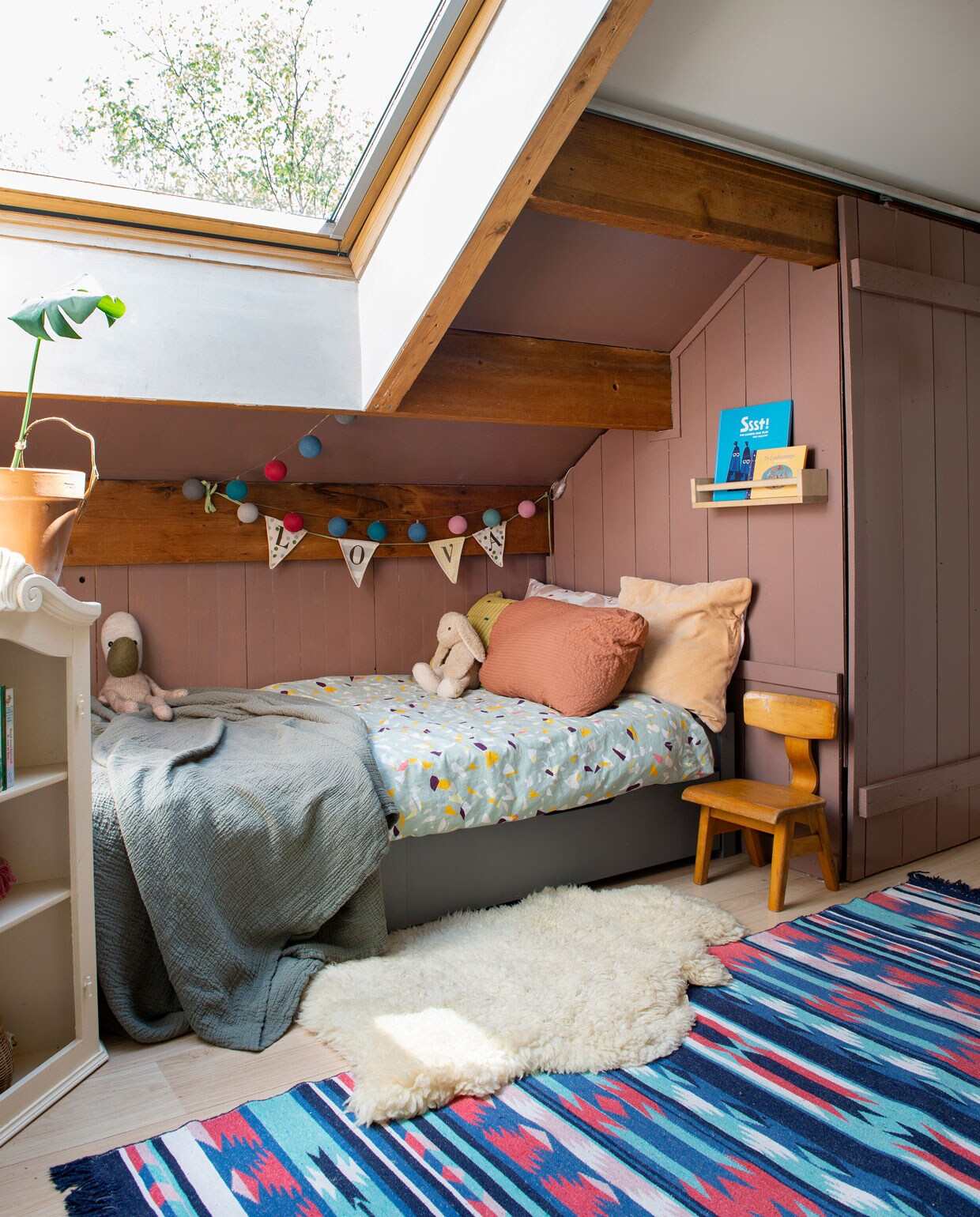 Beddengoed Wehkamp, terrakleurig sloop Crisp Sheets, roze fluwelen kussen Hema, sprei H&amp;M. Vloerkleed gekocht op het strand van Texel, schapenvacht Noordermarkt Amsterdam. Kast op straat gevonden en roze geschilderd. Plank Ikea, vintage stoeltje. Knuffel Artis de Partis, het konijn was een cadeau. Naamslinger van winkel die gesloten is. Lichtslinger Sjakies Haarlem. Muurverf Oud Roze van Karwei.