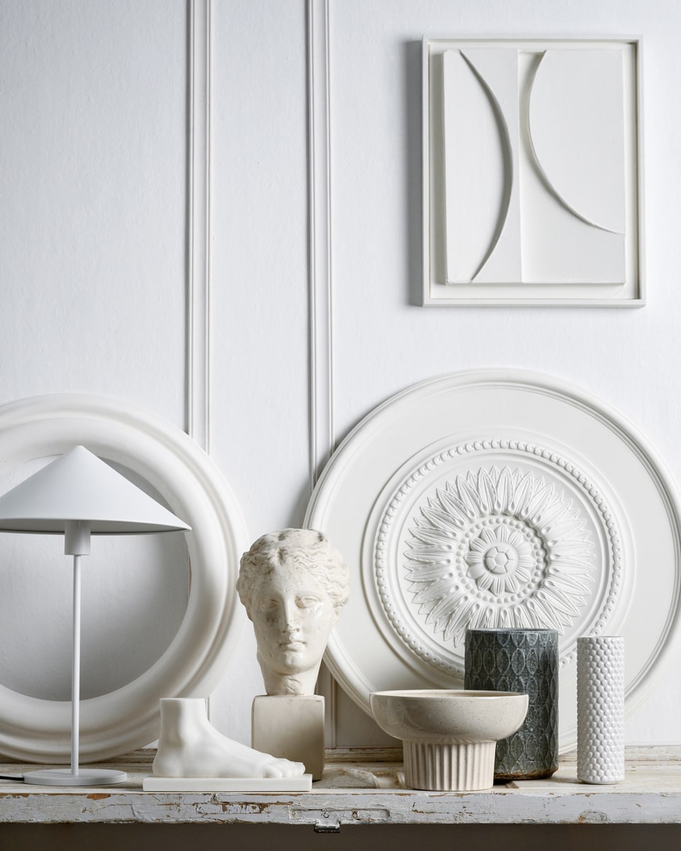 Latten decorlijst mdf, lengte 260 cm per stuk vanaf € 5,50 (karwei.nl). Schilderij, prijs op aanvraag (artinreturn.nl). Ornament PU Rozet 76×76 cm vanaf € 85,-, ornament ring 72x72cm vanaf € 70,-, sculptuur Venus vanaf € 60,- (het-schippertje.nl). Sculptuur voet € 59,95, witte metalen lamp Triangle, 58×40 cm (hxØ) € 119,- (hkliving.nl). Kom Indi met spikkelglazuur, 26×16 cm (hxØ) € 35,- (made.com). Vaas Bubble van Bloomingville € 21,-, vaas Mystic print van Serax, 25,5×17 cm (hxØ) € 22,- (vtwonen.nl). vtwonen 03-2020 | Styling Marianne Luning | Fotografie Stan Koolen | Assistentie Niels Kist en Roos van Bruggen