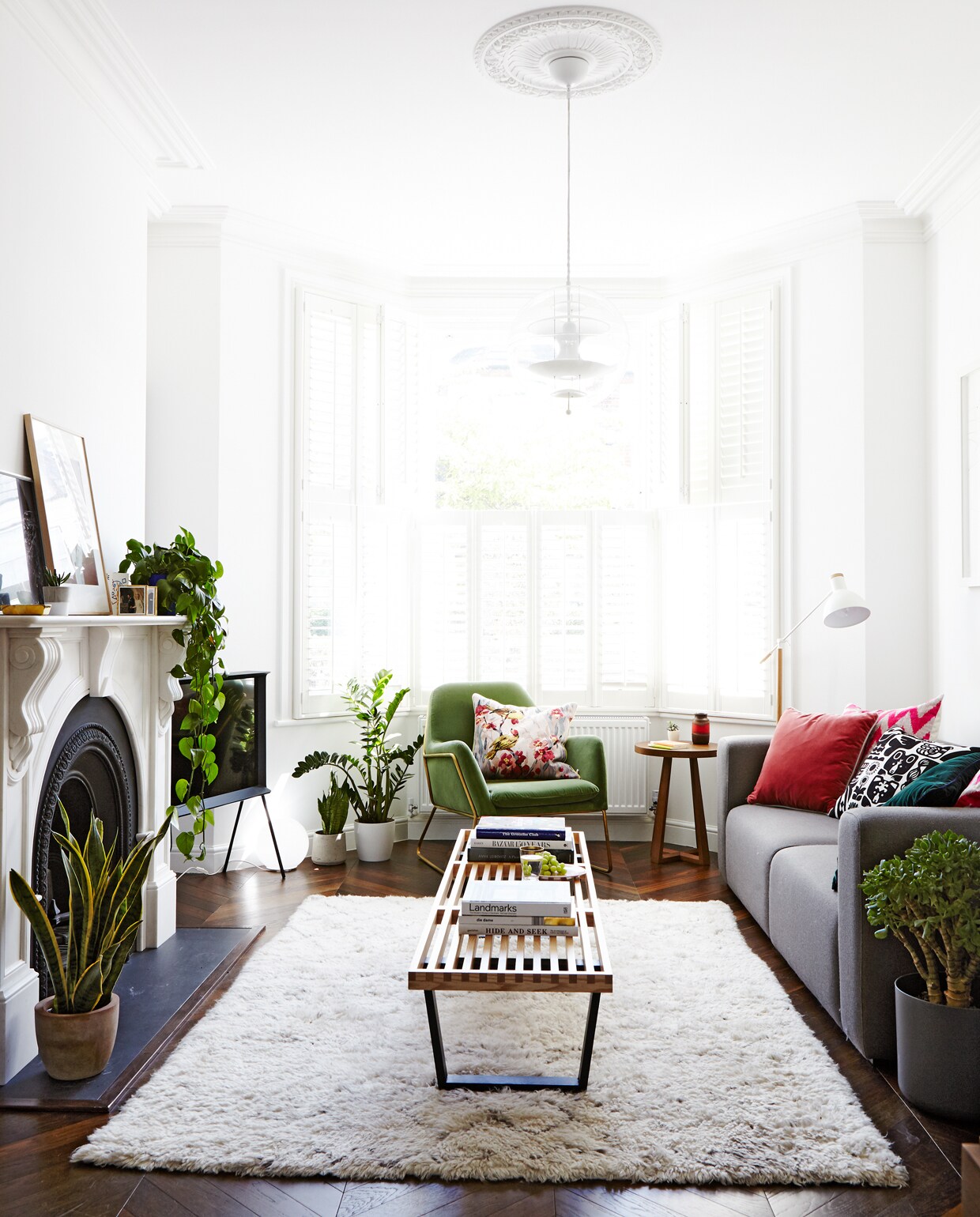 De open haard herinnert aan de Edwardiaanse oorsprong van het huis. Het houten bankje is van George Nelson voor Vitra, bank van Hay, stoel van made.com.