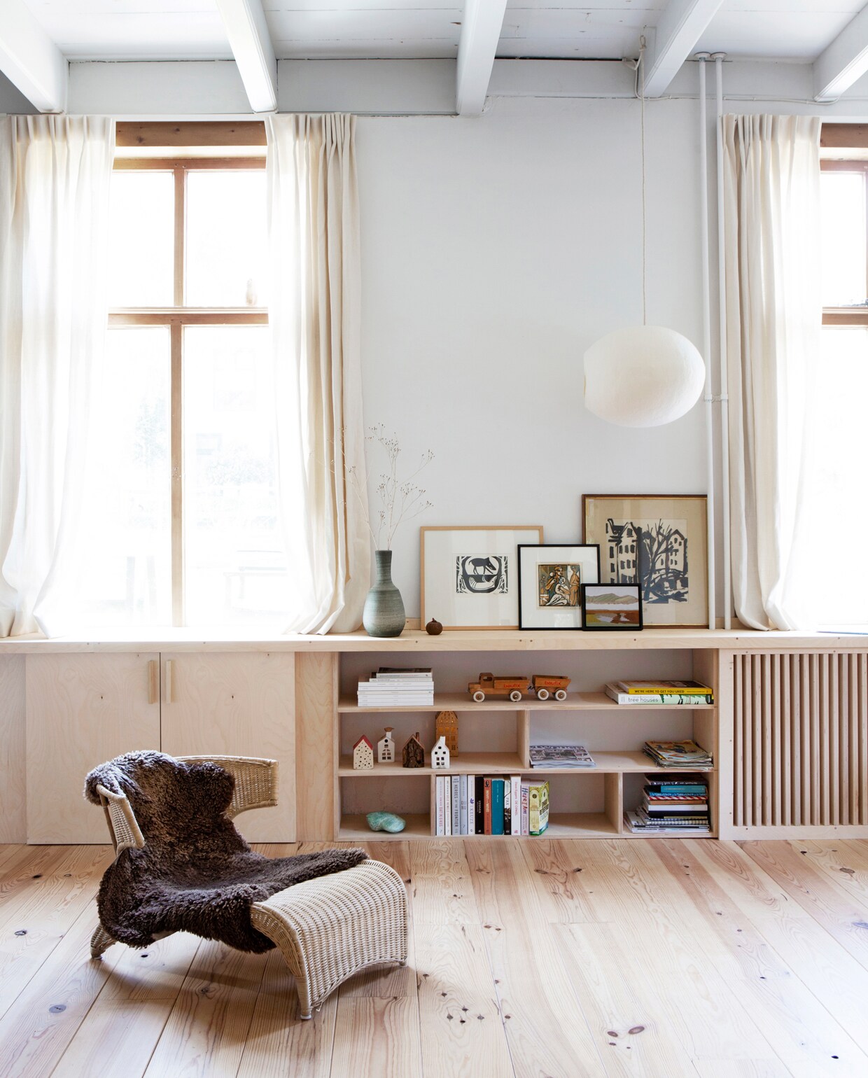 Radiatorombouw/kast, gemaakt door Woodchuck. Linnen gordijnen uit het vorige huis laten vermaken. Plafond in kleur Wood Ash van Little Greene. Alle witte muren in kleur Wevet van Farrow &amp; Ball. Schilderijen van links naar rechts: ​Plony van Zuylen, Herman Reijers, Frank Dekkers en Herman Reijers (Herman Reijers was een oom van Boris). Wolvilten lamp Lumalano. Stoeltje vintage Ikea. Vaasje vintage marktplaats.nl. vtwonen 13-2019 | fotografie Jeltje Fotografie