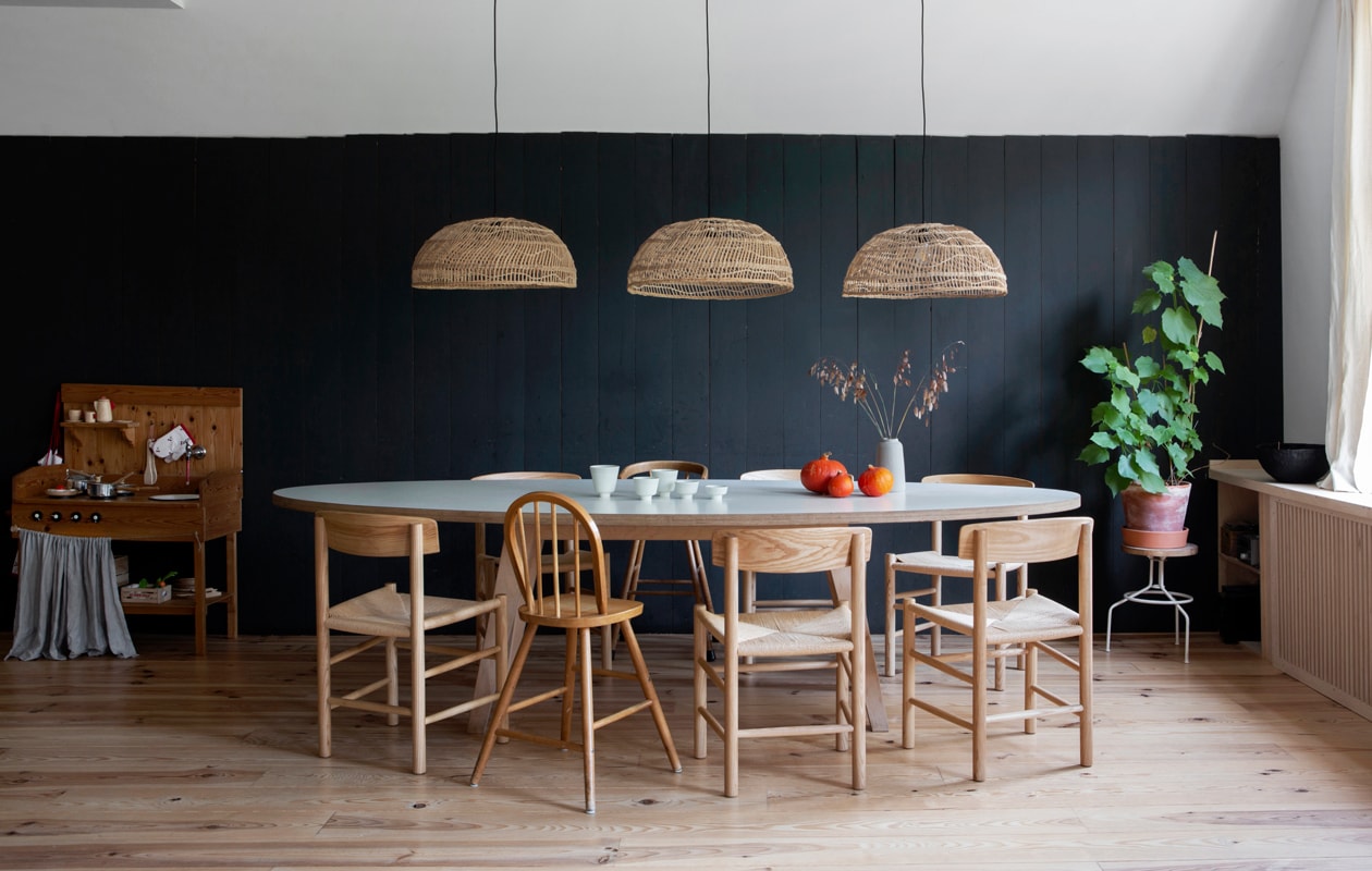 Muurverf Black Blue van Farrow &amp; Ball. Tafel ARP Design. Stoelen replica’s van Borge Mogensen’s J39 via Swivel UK. Kinderstoelen marktplaats.nl. Krukje Hema. Lampen HKliving. Schaaltjes, kopjes en vaasjes van Iittala, Broste Copenhagen, Annemieke Boots Ceramics, Søstrene Grene. Kommetjes links van Atelier Juliette Warmenhoven. Grenenhouten vloer, afgelakt met Skylt, via Wood and Stones. vtwonen 13-2019