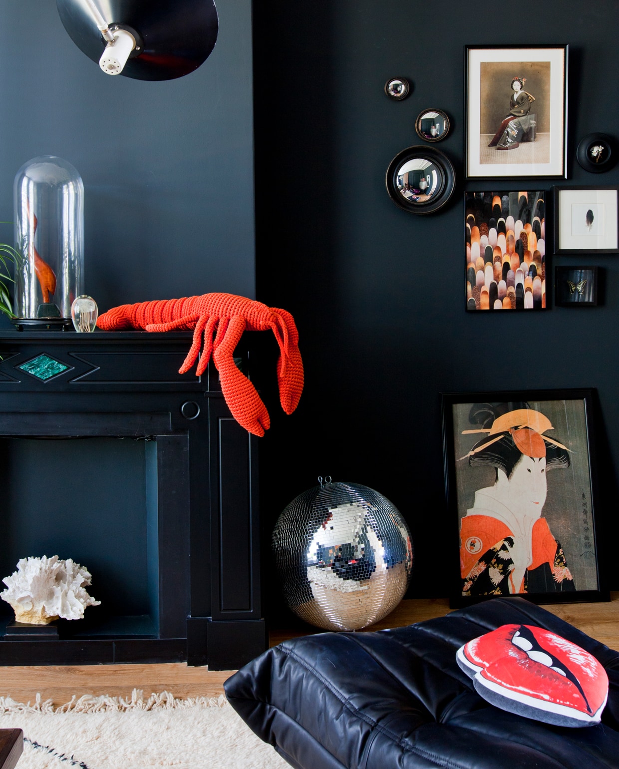 De wanden van de donkere zitkamer zijn geschilderd in Off-Black van Farrow &amp; Ball. Kreeft van Anne-Claire Petit, poef van Ligne Roset met daarop een zijden mondkussen van Age of Reason Studios uit Londen. Op de muur een verzameling kunstwerken, veelal gekregen van vrienden, en ronde spiegeltjes van Wauw Warenhuis in Den Haag. Ook de discobal was een cadeau.