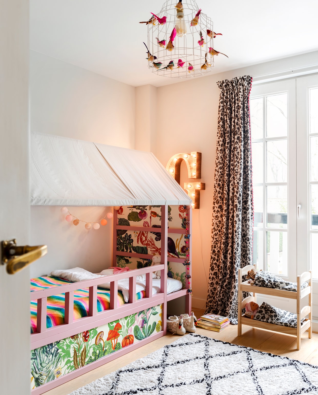 Sophie maakte het Ikea bed van Guusje uniek door er een dakje over te spannen en het te behangen en te verven. De letter G komt uit Amerika. Gordijn met dierenprint gemaakt van stof van Thibaut. Lamp Dutch Dilight. vtwonen special binnenkijken 12-2019 | styling Lindividu | fotografie Stan Koolen, CocoFeatures