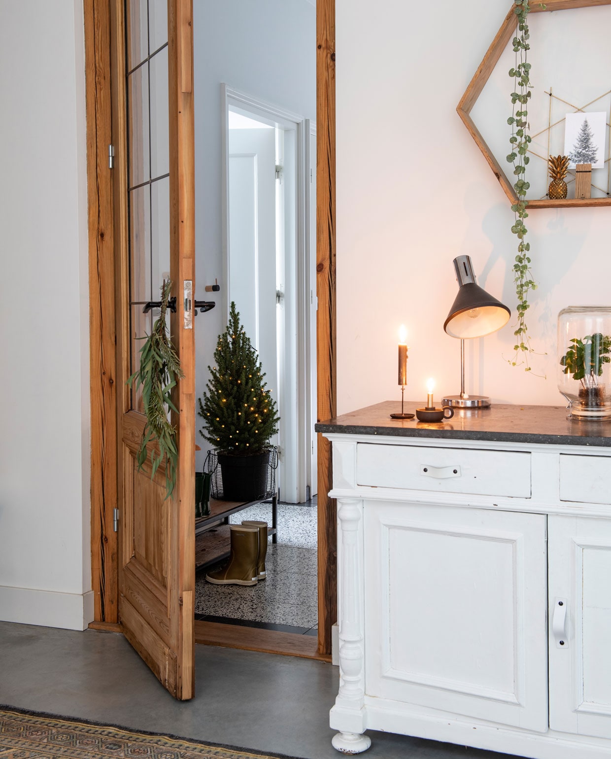 De antieke witte kast was van de vorige bewoonster. Vintage lamp gekocht op een marktje. Kandelaars Hema, plant in glazen pot van Pikaplant. Schoenenrek in de hal en frame boven kas gemaakt door Robuust Maatwerk. vtwonen 12-2019 | styling Babs Dols | fotografie Louis Lemaire | productie insidehomepage