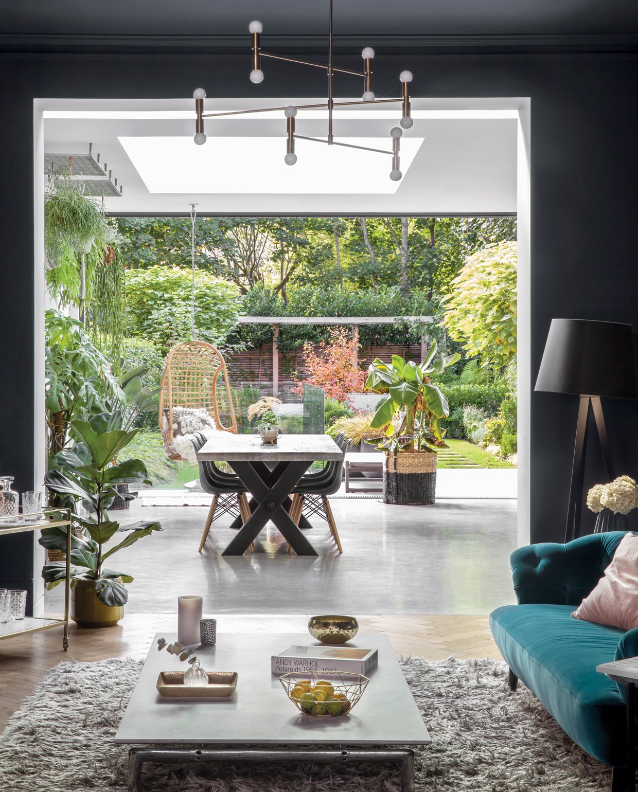 De eetkamer met uitzicht op de binnentuin. De grote glazen schuifdeuren en dakramen laten zoveel mogelijk licht toe, wat Sommer het allermeest mist uit haar geboorteland Australië. ‘De hangstoel in de keuken is de perfecte plek om de tuin te bekijken terwijl de seizoenen veranderen.’ De eettafel is van Amode, de grijze Eames-stoel van Vitra. Het wandframe en alle accessoires zijn van House Curious. vtwonen 01-2020 | fotografie Rei moon/living Inside