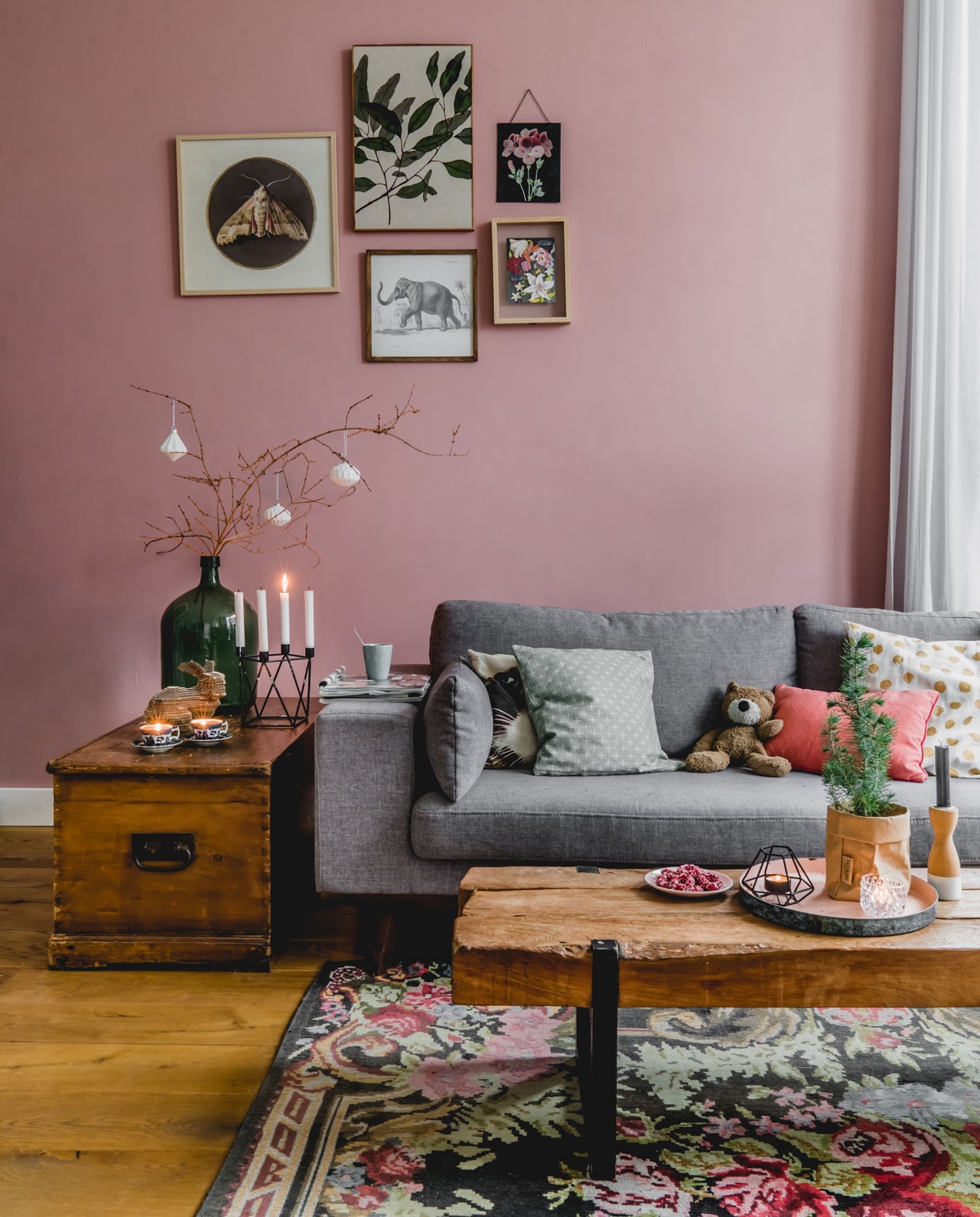 De oude suitedeuren vonden ze terug in de schuur. Muurverf kleur Ritueel van Histor. Bank en gouden lamp van wehkamp.nl, kleed en lijsten met prints op de muur van Kwantum, dekenkist van Marjoleins oma, tafel van De Troubadour. De tak komt in kerstsfeer met decoraties, die ze zelf maakten met een 3D-printer. Vaas van Hof Tongerlo, kandelaar cadeau gekregen, konijn zelfgemaakt, herkomst draadmand onbekend. vtwonen 12-2019 | productie Features &amp; More | styling Wilma Custers | fotografie Ivar Janssen