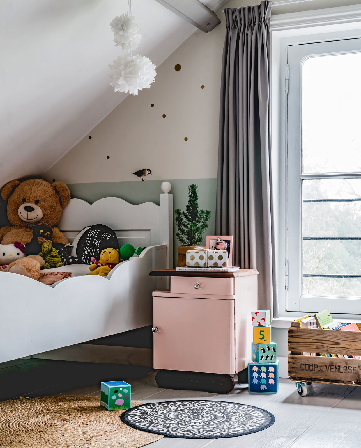 De lichtgrijze balken op de kamer van Soof hebben dezelfde kleur als de vloer, Balanced Breeze van Flexa. Het nachtkastje is gevonden op marktplaats.nl, Marjolein schilderde het roze. Ook het bed vonden ze daar. Vloerkleden Kwantum en Kruidvat, krat op wielen via via uit een oude fabriek, vogel op muur Kek Amsterdam, herkomst lamp onbekend. vtwonen 12-2019 | productie Features &amp; More | styling Wilma Custers | fotografie Ivar Janssen