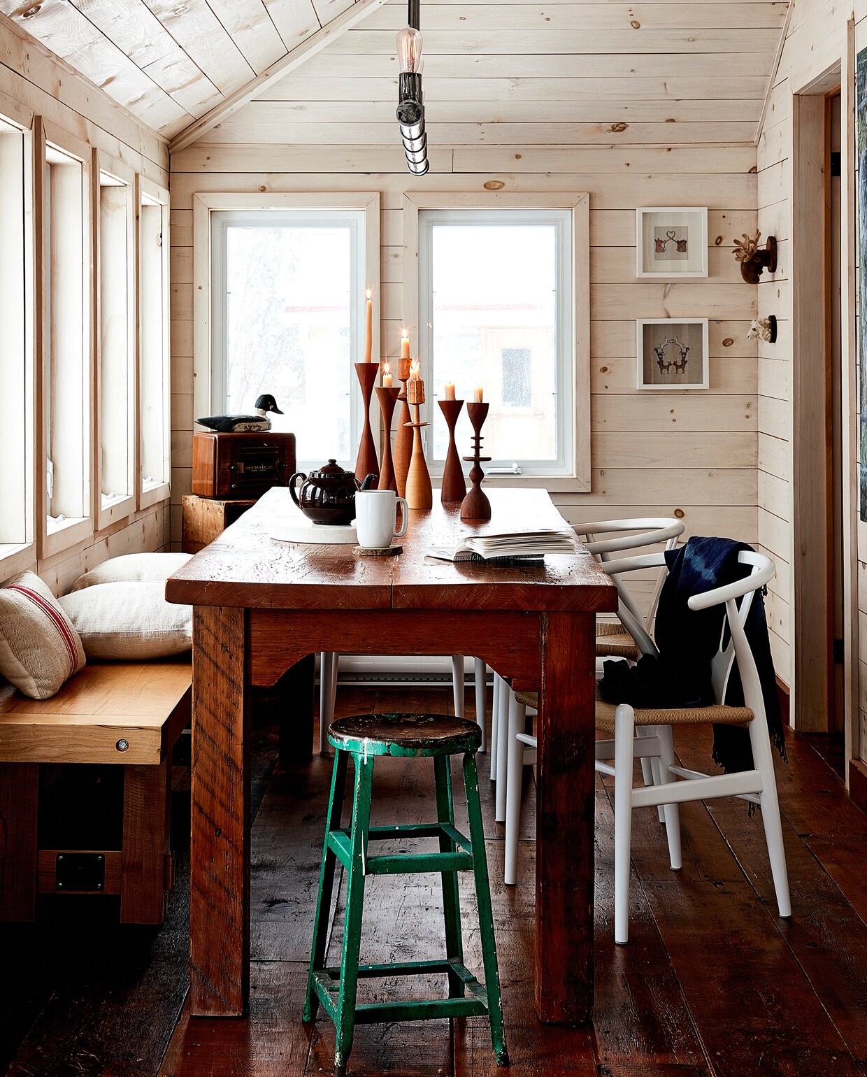 Omdat de eetkamer zo smal is en een standaard tafel niet paste, is de tafel op maat gemaakt. Wishbone chairs van Hans J. Wegner (Carl Hansen). Shelley ontwierp de lamp zelf en liet hem maken door een lokale smid. Kandelaars van Treeware Woodworks.