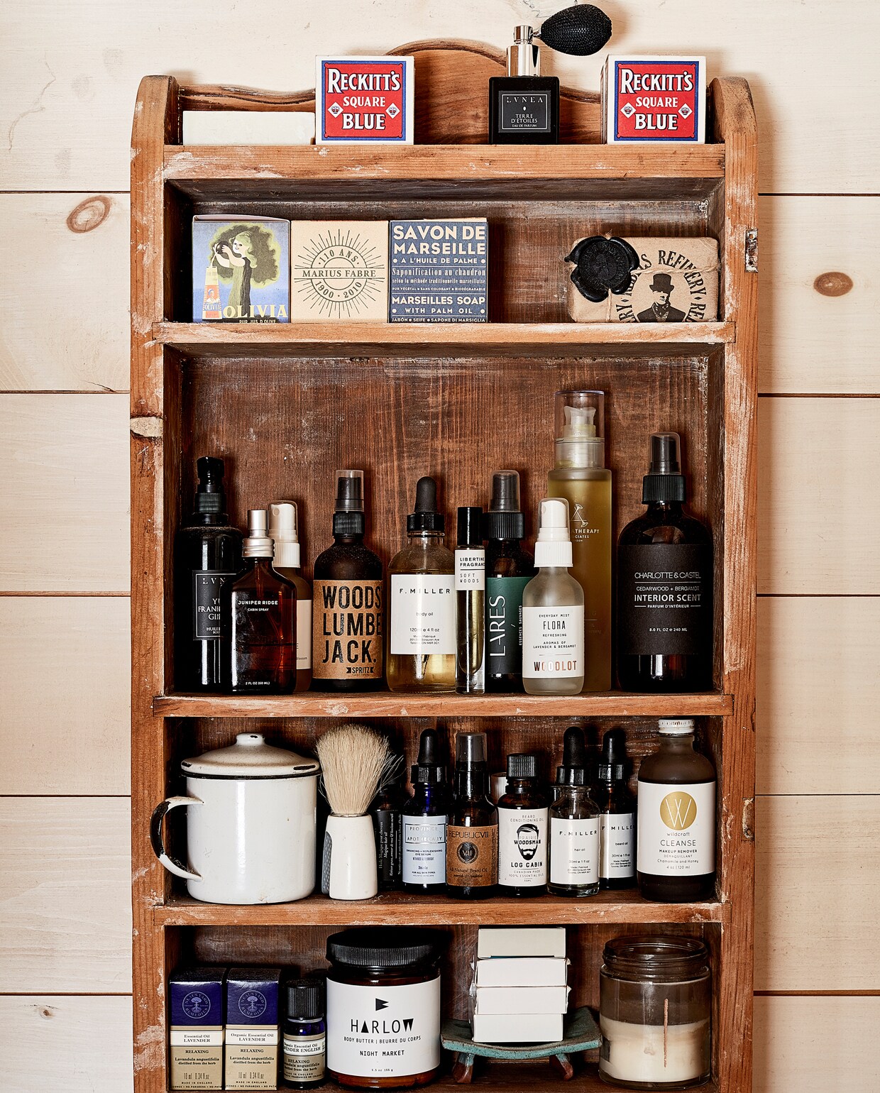 Een rustiek houten kastje steekt mooi af tegen de blond houten wand. De verzorgingsproducten zijn zo veel mogelijk in een kleur gekozen; het zwart dat ook op andere plekken in huis als accentkleur terugkomt. Dat versterkt het serene zen-gevoel in de badkamer.