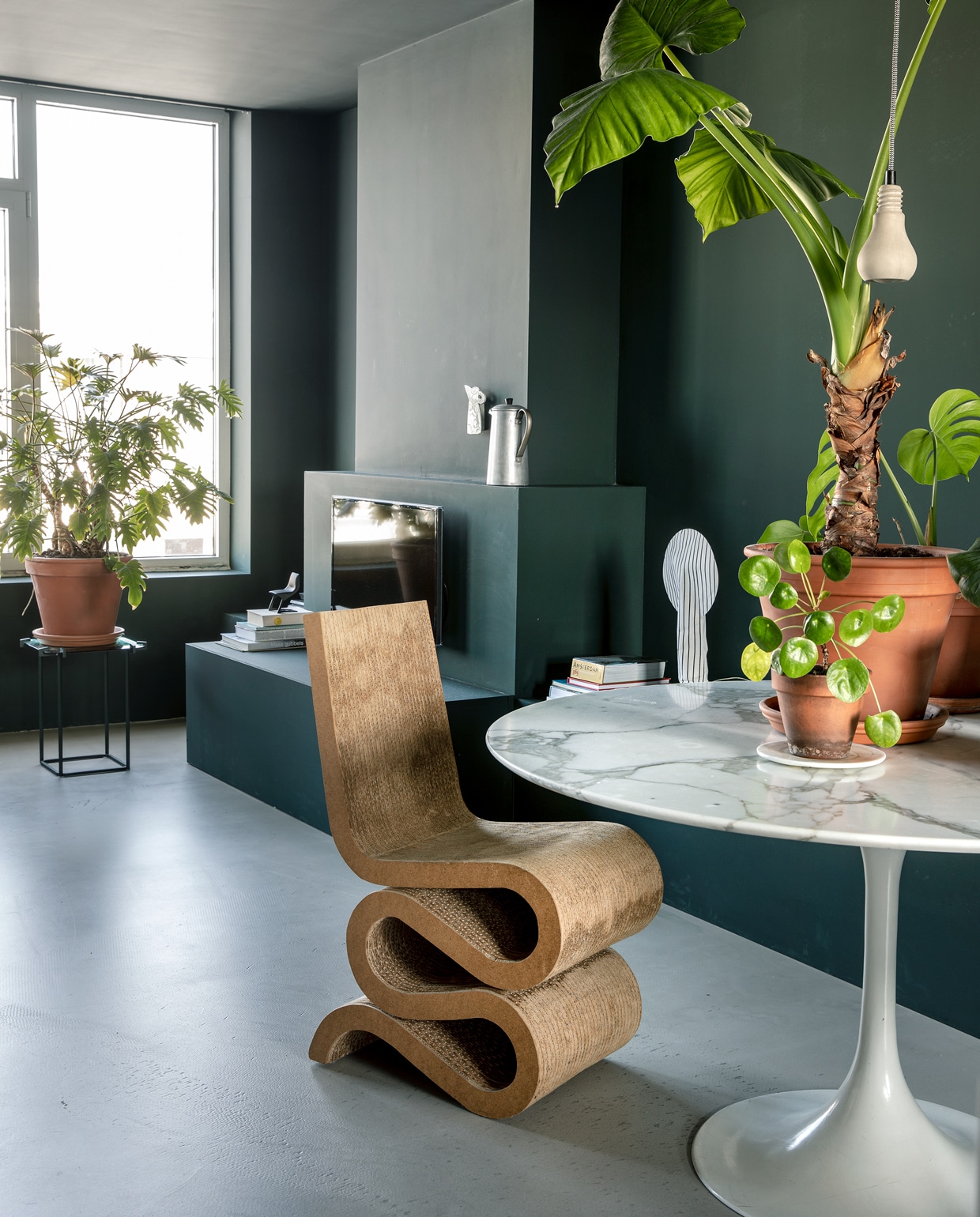 Vintage tafel Tulip van Eero Saarinen voor Knoll Studio. Planten en potten Intratuin. Betonnen hanglampen Edison van Tove Adman via Anno Design. Wiggle Side Chair van Frank Gehry is een erfstuk. Verfkleur RAL 6012 zwartgroen. vtwonen binnenkijkspecial 12-2019 | styling José Martens | fotografie Peggy Janssen