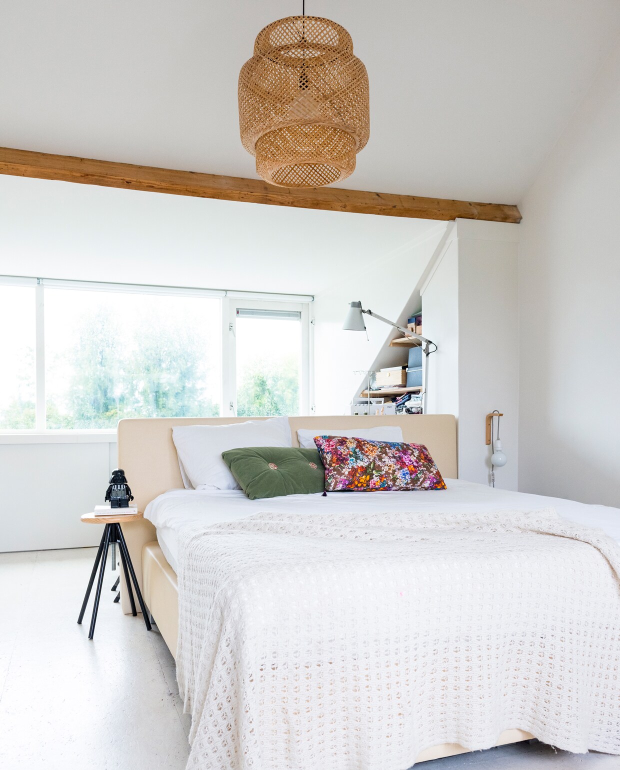 In de slaapkamer van de ouders op de bovenste verdieping zat voorheen een vliering. Deze is opengebroken voor meer ruimtelijkheid, de balken zijn daarbij in het zicht gelaten voor de sfeer. Krukje van de Action, daarop een Star Wars-wekker van bol.com, hanglamp van Ikea, bed van lokale beddenwinkel in Rotterdam, sprei onbekend, wandlampje zelfgemaakt met spullen van snoerboer en een plankendrager, metalen lamp van Erco, beddengoed Essenza.