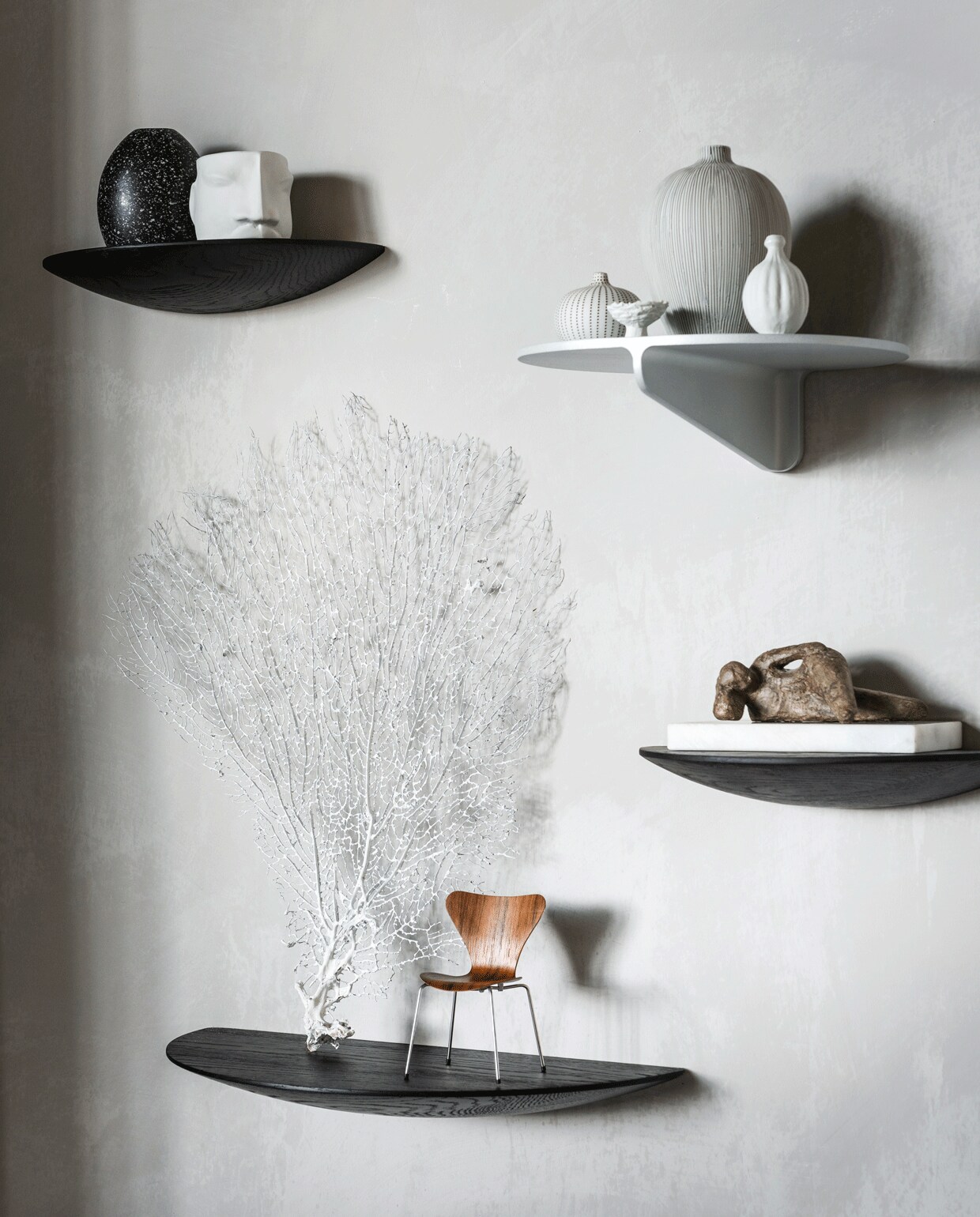 Muurverf kleur North (bauwerkcolour.com). Zwarte houten wandplanken van Menu, maat M, maat L (vtwonen.nl). Metalen wandplank Museum (stringfurniture.com). Witte porseleinen mok met gezicht van Gloria Landenberger (studiosomee.com). Kleine vaas met strepen, grote vaas met strepen, handgemaakte vaasjes (letoile.store). Walnoothouten miniatuur vlinderstoel, beeld op marmer van Dominic Lansen (coosdewitwonen.nl). Overig privébezit.