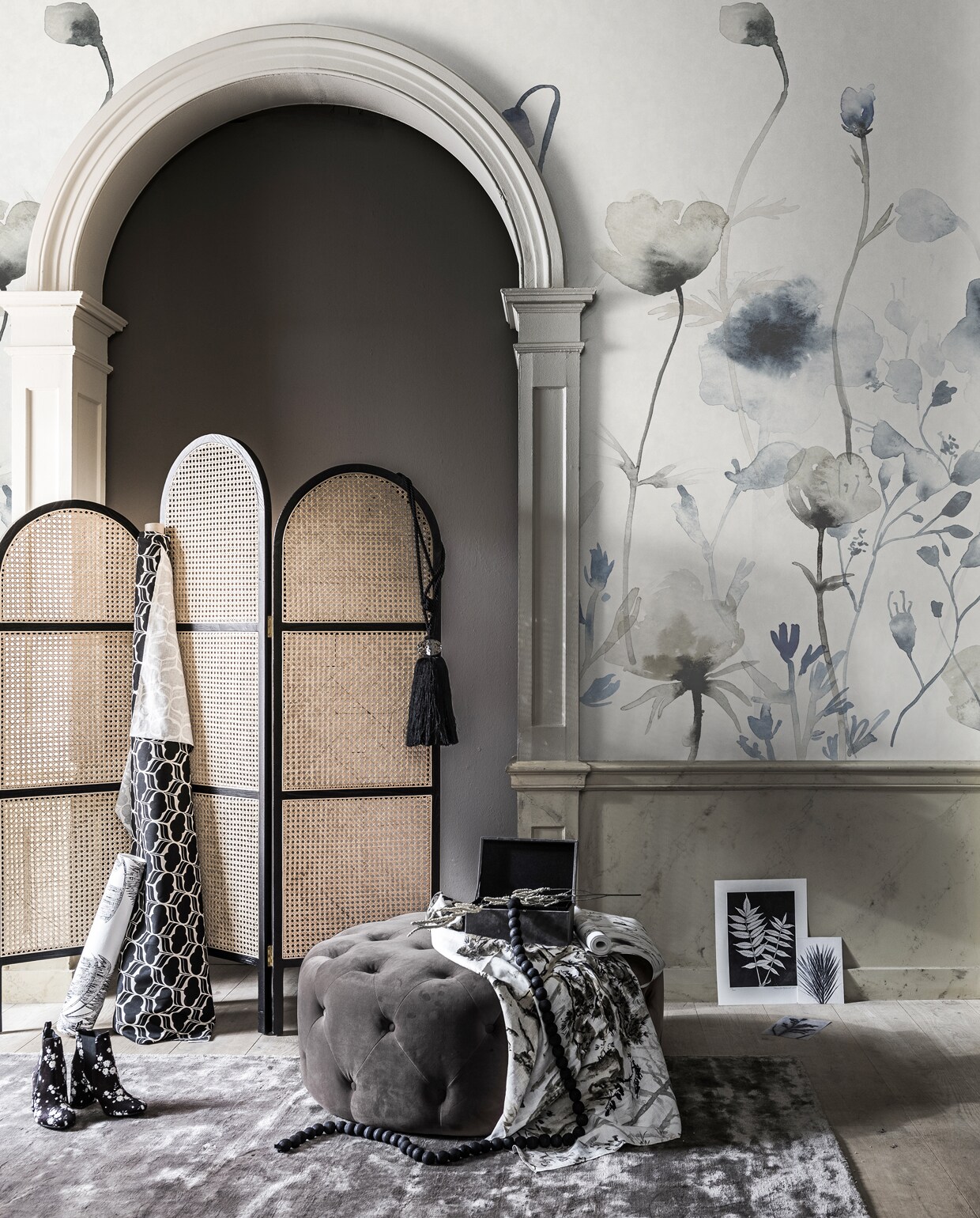 Beige verf op de muur Londinium van Graham &amp; Brown (grahambrown.com). Behang Morangen met grote bloem van Sandberg Wallpaper (ankevangoor.com). Vliesbehang Palm Tree, kamerscherm van HK Living (vtwonen.nl). Kaarten met bloemenprint , poster met bloemenprint (pernillefolcarelli.dk). Grijs kleed, donkergrijze poef (made.com). Zwarte kralenketting (homestede.nl). Schoenen met bloemenprint (hm.com). Stof op rol, grijs doosje van stof (kwantum.nl). Embrasse zwart met Swarovski steen van Osborne &amp; Little, poef (made.com). Stof met bloemenprint Jade Temple van Designers Guild (wva.nl). Droogbloemen (tuinvanjudith.wordpress.com). vtwonen special 03-2019 | Fotografie Sjoerd Eickmans | Styling Liza Wassenaar