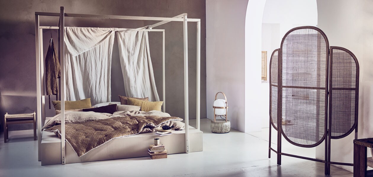 Kalkverf van Pure &amp; Original in kleur North Sea Silt (deruverfenbehang.nl). Bed van Combitex (com-anders.nl). Linnen lappen (boerenbonthal.nl). Kruk van Hans Wegner voor Fredericia, dinerbord van Hasami porselein, Japanse Susumu theepot, lamp van kersenhout en glas, kussenhoes van gewassen linnen in okergeel, 40×60 cm, koffiebeker van keramiek, theelepel, linnen dekbedovertrek in kleur Sahara zand, 220×240 cm, linnen kussenhoezen in kleur Karamel, 50×70 cm (pantoufle-design.nl). Kamerscherm 80x130x3 cm (hxbxd) (Nordal). Poef van keramiek (angeliquehomberg.nl). Houten plankje (fijnhout.nl). Oranje kussens, 52×72 cm, linnen kussensloop Atlas Sierra, 50×75 cm, gewassen linnen quilt Atlas Sierra, 90×190 cm, kimono van gewassen linnen Atlas Sierra (gabrielle-paris.nl). Boeken privébezit. ,