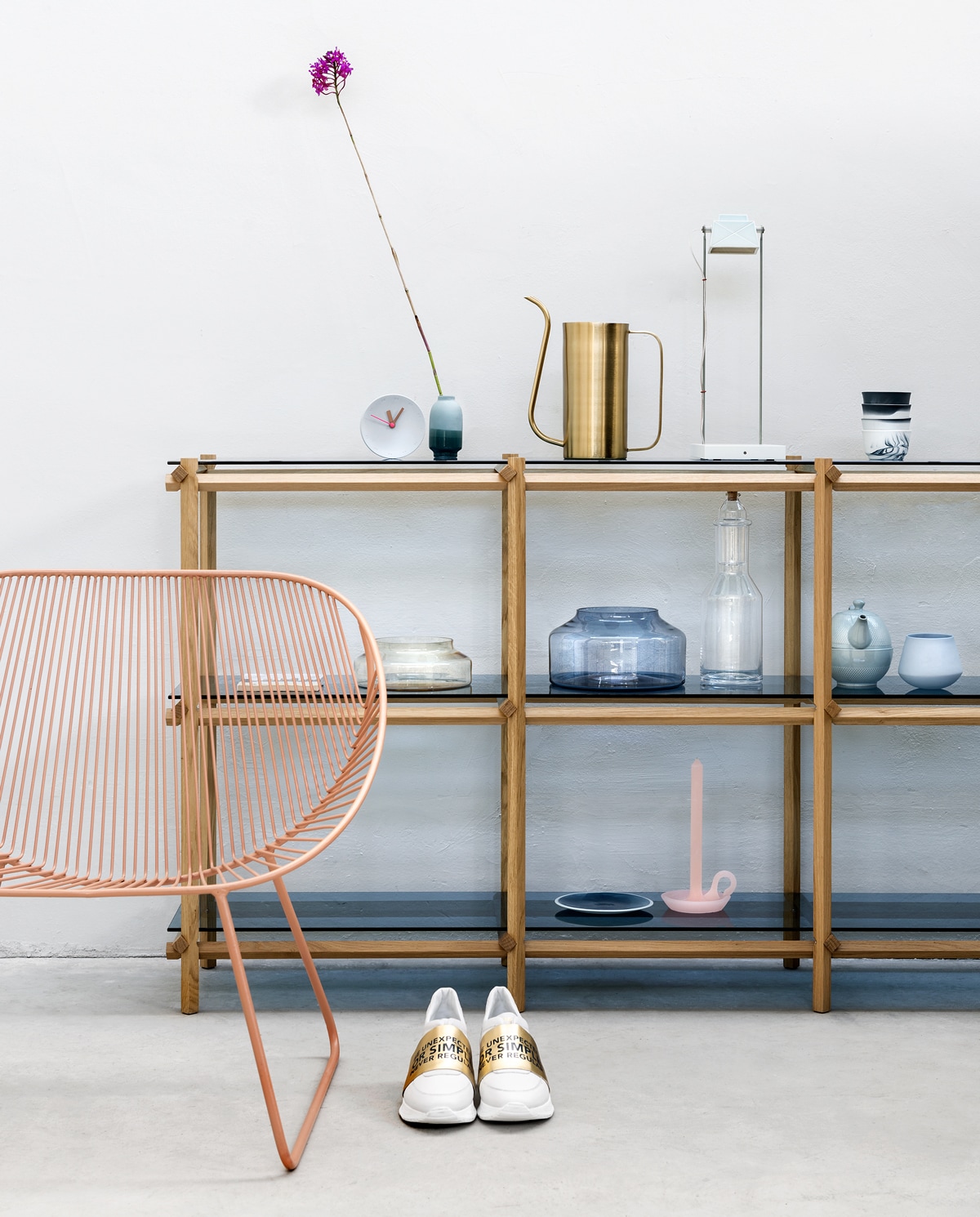 Muurverf RAL5800 (Sikkens). Dressoir met blauw glas en houten frame € 2180,-, gestapelde kopjes van Pigments &amp; Porcelain, vanaf € 33,06 per twee (vij5). Storytile met print van stad € 27,50 (Pols Potten). IJzeren loungestoel in Dusty Roze van Madam Stoltz € 149,- (deens.nl). Gieter van Nordal € 37,95 (vtwonen.nl) Bureaulamp € 415,- (Scheublin &amp; Lindeman). Glazen schalen in blauw en transparant glas, inclusief houten deksel, vanaf € 130,-, fles € 89,- kaars in kandelaarvorm € 14,95 (Ontwerpduo). Porseleinen klok € 55,-, porseleinen dipvaas € 29,-, kop naast theepot € 19,50, geglazuurd porseleinen bord € 12,95 (Studio Harm en Elke). Theepot € 59,- (Nordal). Sneakers (10days). vtwonen 06-2018 | Styling Marianne Luning | Fotografie Stan Koolen