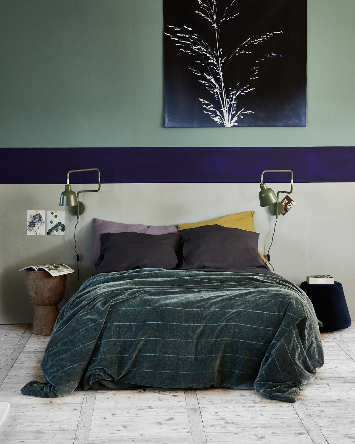 Verfkleur op de wand boven Atria (pure-original.nl). Kleur onder Soft Grey (karwei.nl). Kleur blauwe band Tai Sapphire 116 (littlegreene.com). Print op doek, blauwe poef naast bed (goeds.nl). Wandlampen (fonq.nl). Houten kruk met rode bovenkant (polspotten.nl). Dekbedhoes (ikea.nl). Linnen roze kussen (urbannatureculture.com). Sprei, velvet (hkliving.nl).