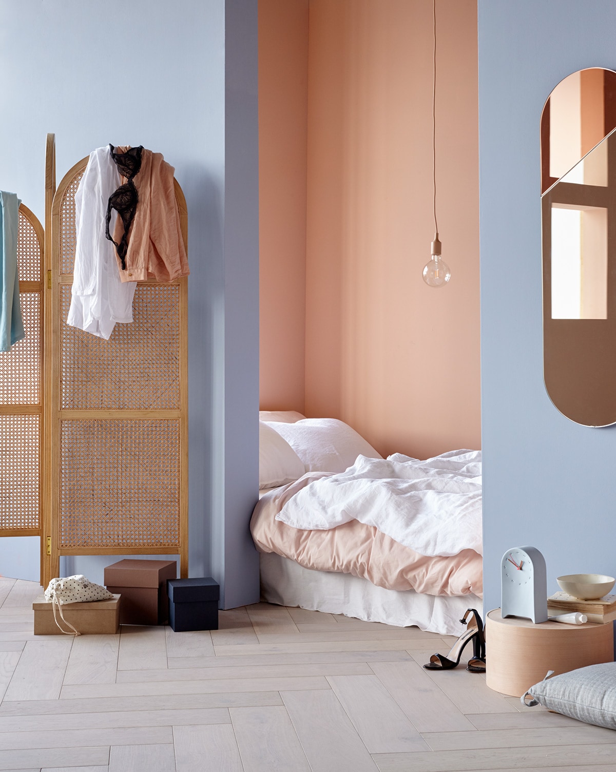 Muurverf op de voorste wand Teder, achterwand Vla van HistorOne (deruverfenbehang.nl). Parket visgraat eiken wit geolied van vtwonen (karwei.nl). Roze hanglamp (vtwonen.nl). Kamerscherm, spiegel (hkliving.nl). Kleding (paviljoennoord.com). Donkerroze en blauwe doos, set van vier, houten hoedendoos (loods5.nl/design). Roze katoenen dekbedovertrek met kussensloop, wit linnen dekbedovertrek met kussensloop, wit hoeslaken, zandkleurige kom (hm.com). Lichtblauwe klok van keramiek (studioharmenelke.nl). Tube handcrème, lichtblauw kussen met strikken (loods5.nl). Overig privébezit. vtwonen 06-2019 | styling Danielle Verheul | fotografie Petra Steenkamer