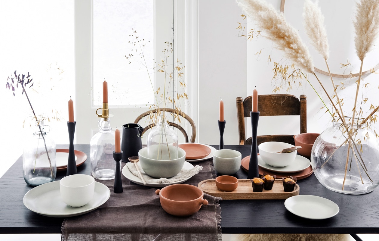 Flesvaas met oor, 26,5×13 cm (hxØ) € 4,95, goud- kleurige metalen fleskandelaar, set van 2 € 12,95, wit bord Ø 20 cm € 7,95 (ook verkrijgbaar in andere formaten), zwarte metalen kandelaar vanaf € 14,95, grijze keramieken kom vanaf € 9,95, witte kom Ø 9 cm € 4,95 (ook verkrijgbaar in andere formaten), acaciahouten dienblad, 40,5×14,5×3 cm (lxbxh) € 29,95 (vtwonen.nl) vtwonen 02-2020 | styling Kim van Rossenberg | fotografie Ernie Enkelaar