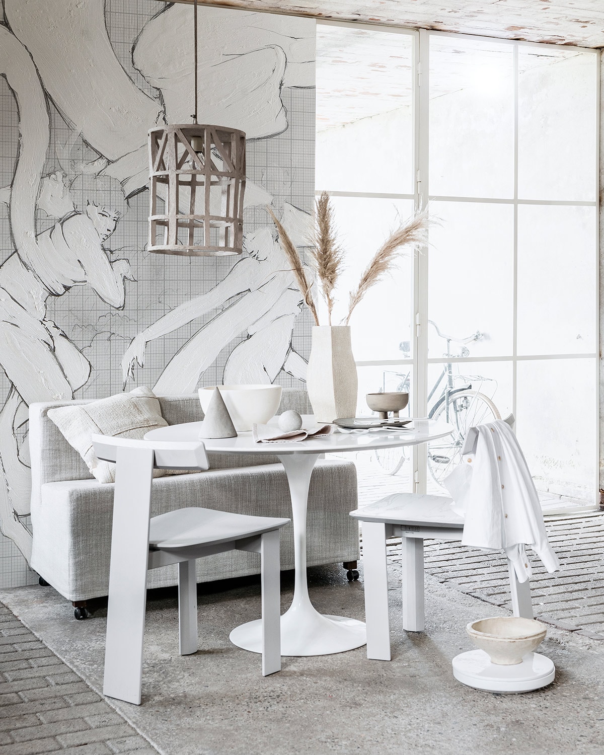 Behang (wallanddeco.com). Ronde tafel (neeflouis.nl). Bankje, witte stoelen (linteloo.com). Witte blouse (sukha.nl). Lamp met figuur erin, grijze kegel, wit bord met grijze onderkant (serax.com). Kussen op bank (couleurlocale.eu). Beige kom op de grond, platte ronde doos op de grond, grote vaas op tafel theedoek op tafel, grote schaal op tafel (studiopansa.com). Sierstuk ronde bal, rond bakje op pootjes (101cph.com). Droogtakjes (tuinvanjudith.wordpress.com). Bestekset vierdelig (lisannevanzanten.nl).