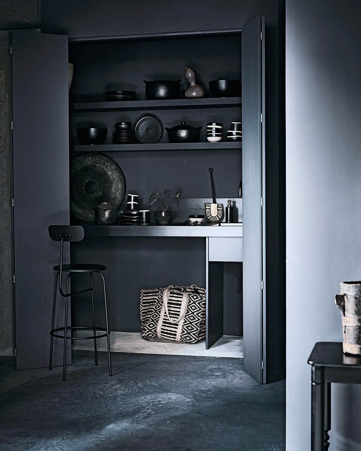Keukenontwerp van Mvn&amp;i, sidetable, grote metalen antieke schaal (mvninteriors.com). Black pottery potten met deksel, black pottery kommen, bekers en kommen met witte rand (couleurlocale.eu). Grote zwarte diepe schalen, zwarte borden, kommen met zwarte rand (householdhardware.nl). Gevlochten tas, kom met plantje, vliegenmepper (madamstoltz.dk). Aardenwerken pan met deksel (aurapeeperkorn.nl). Barkruk Afternoon van Menu (goeds.nl). Zeeppompje (nordal.eu).