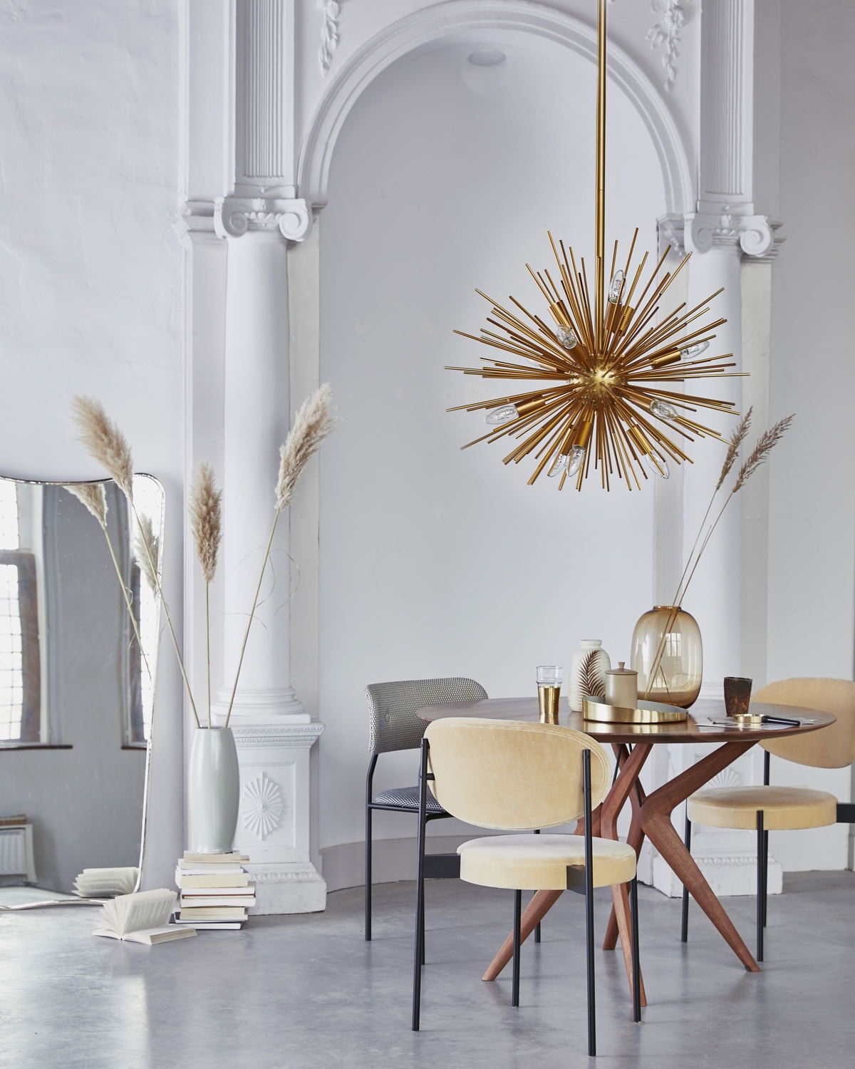 Ronde eettafel van Artisan, grijze stoel Coco van Gubi (goeds.nl). Eetkamerstoelen van Verner Panton (mobilia.nl). Gouden hanglamp (madamstoltz.dk), spiegel (nordal.eu), grote grijze vaas, tadelakt potje (maisonnl.com), glazen bruine vaas (hm.com), gouden dienblad (bolia.com). Vaas met bladdessin (madamstoltz.dk). Overig privébezit.