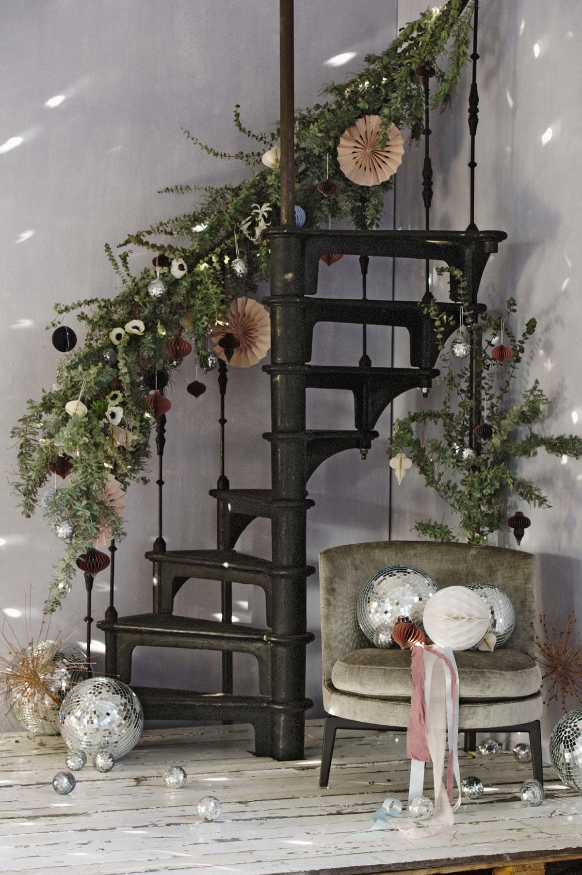 Muurverf lichtblauw kleur Iris (bauwerk.com.au). Trap inclusief leuning en spijlen (Jan van IJken). Ballen van karton, ballen van karton, discoballen (H&amp;M). Versiering van trap met groen en bloemen, gedroogde oude tak (judithslagter.nl). Grijze stoel met zwarte poten (Edha Interieur). Discoballen van Rice (vtwonen.nl). Waaier van papier (Dille &amp; Kamille). Grote discobal (Spoor 38). Lint (Wol en Zo).