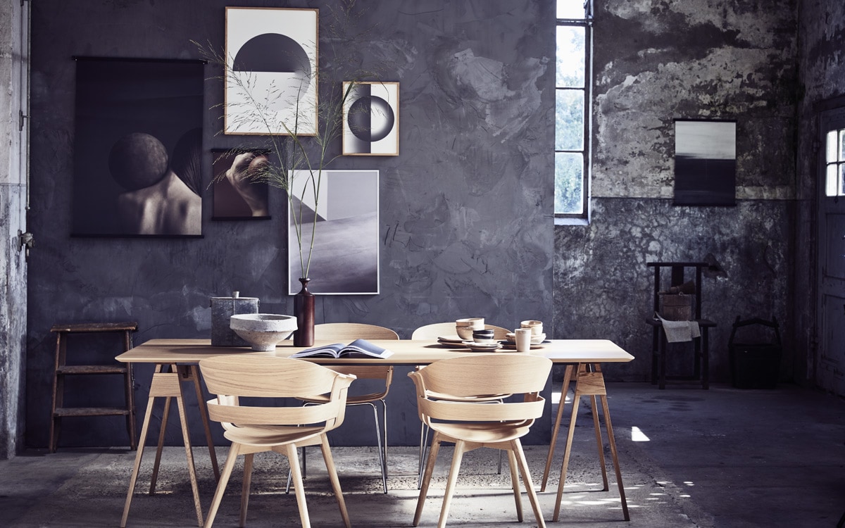 Poster met rug en bal Close Contact 01 van Norm Architects, 70×100 cm , posterhouders Magnetic Stiicks, walnoot, breedte 73 cm, poster klein met bal en rug Close Contact 04, 30×40 cm, lijst eikenhout, 30×40 cm, poster boven met grafische cirkel groot EO Shapes 01 van Erik Olovsson, 50×70 cm, lijst eikenhout, 50×70 cm, kleinere poster met grafische cirkel EO Shapes 02, 30×40 cm, lijst eikenhout, 30×40 cm, poster met foto van grafische vlakken Details 02 van Rich Stapleton, 50×70 cm, witte aluminium lijst, 50×70 cm, poster met zwart-grijs kleurverloop Charcoal 01 Lemon, 50×70 cm, posterhouders Magnetic Stiicks, zwart gebeitst essenhout, breedte 53 cm (). Eikenhouten eettafel van Design House Stockholm,, stoelen met houten poten van Design House Stockholm, stoelen met verchroomde poten van Design House Stockholm (). Papier-maché schaal, metalen fles, antieke stoel, oude houten emmer met hengsel, stoommandje, kwast (). Bruine houten vaas (). Servies op tafel: kommen, bekers, bordjes, houten borden (). Muur gestuukt met Marrakech Walls van Pure and Original in kleur Thunder Sky (). Trapje privébezit.