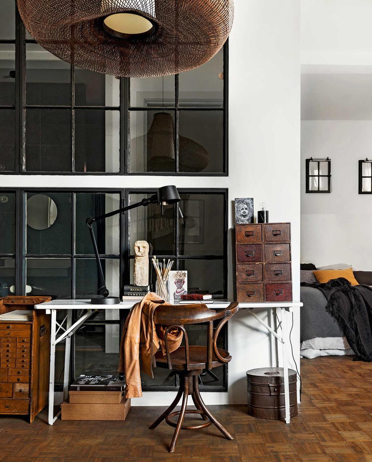 Antieke bureaustoel à la Thonet uit de jaren 30, antiek ‘cartonniere’ ladenblok uit de jaren 30, antiek werkplaatskastje uit de jaren 30, oude metalen trommel, waarschijnlijk hoedendoos geweest (interieur-vivre.nl). Bureaulamp van Tonone, stenen popje, grijze gebreide deken, boek Move and Work van Malene Birger, portretfoto’s van Afrikaanse kinderen (loftloft.nl). Hanglamp May (Ay illuminate via vtwonen.nl). Op bed: naturel sprei van katoenen mousseline (hm.com), grijze linnen kussens van By Mölle, camelkleurig kussen van By Mölle (vtwonen.nl). Overig privébezit.