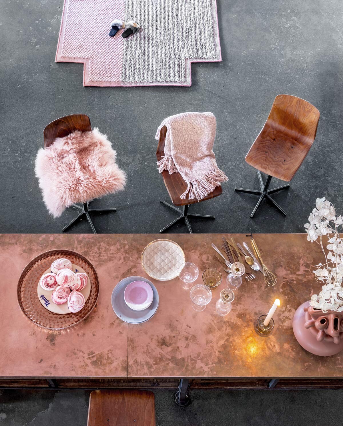 Barkrukken (Neef Louis). Kruisvormig tapijt ontworpen door Patricia Urquiola (Mister Design). Roze lamsvacht van Nordal, geweven roze plaid van Malagoon, parelgrijze borden van Iittala, tapasbordjes met kleurverloop van Royal Doulton, wijnglazen met gouden voet van Bloomingville, goud gedecoreerd bord van Bloomingville, degradé kaars van Mo Man Tai, zilverkleurig mat bestek uit de vtwonen collectie, martiniglazen van Nordal (vtwonen.nl). Schaal van geslagen koper (Pols Potten). Bord met tekst in blauw, roodbruine vaas in samenwerking met Roderick Vos (Social Label). Glazen kandelaar van Madam Stoltz, koper- en messingkleurig bestek van Madam Stoltz (deens.nl). Sloffen (asos.com).