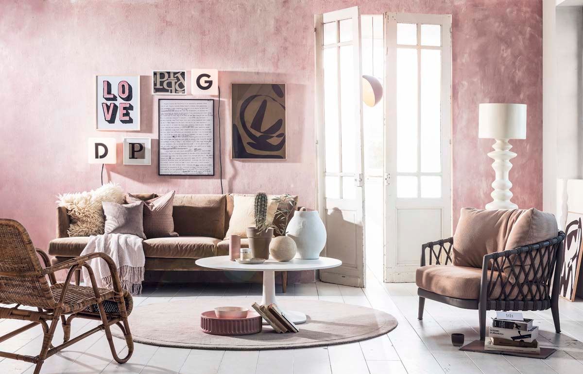 Muurverf kleur Hellebore 275 van Little Greene (). Bank, vloerkleed (). Kussens op bank van links naar rechts: wollen kussenhoes, roze kussenhoes (). Grijs kussen (). Zandkleurige kussenhoes (). Plaid (). Witte staande lamp (). Witte salontafel, grijze fauteuil met roze kussen (). Ronde vaas (). Rotan stoel (). Openslaande deuren (). Witte vaas, roze schaal, roze kom (). Mok op de grond (). Kunst aan de muur bruin (). Zwart-witte tekst gekopieerd uit boek Marilyn (). Tekst Love gekopieerd van kaart (). Cube lamps met letters (). Zwarte hanglamp (). Kunstwerk met letter P zelf gemaakt op karton met stift. Cactus met pot (). Boeken privébezit.