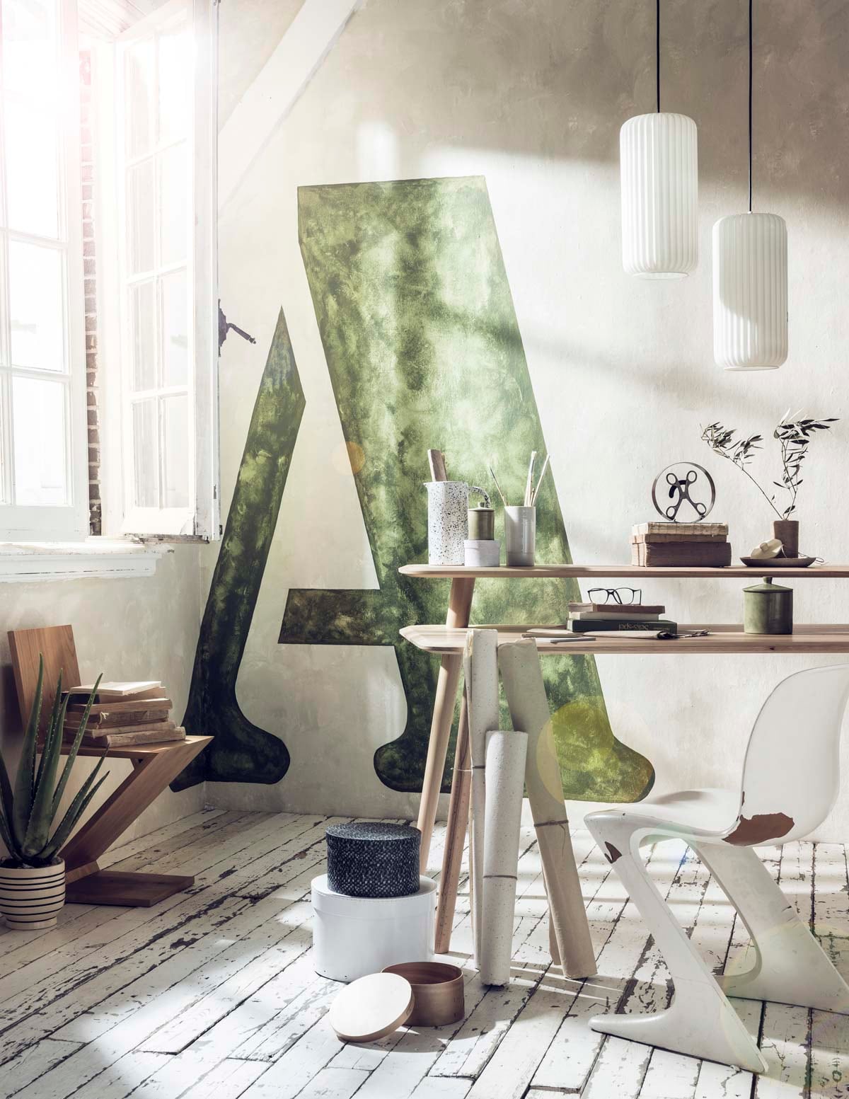 Muurverf kleur Portland Stone 77 van Little Greene, grote A in kleur Olive Colour 72 van Little Greene (). Bureau (). Witte stoel, houten zigzag stoel, witte hanglampen (). Bloempot met streep, witte karaf met zwarte stippen (). Ronde opbergdozen wit en bruin (). Schaar in ronde cirkel (). Bord, pennenbak (). Kleinste potje, groen potje (). Planten (). Overig privébezit. vtwonen 07-2018 | Fotografie Sjoerd Eickmans | Styling Liza Wassenaar