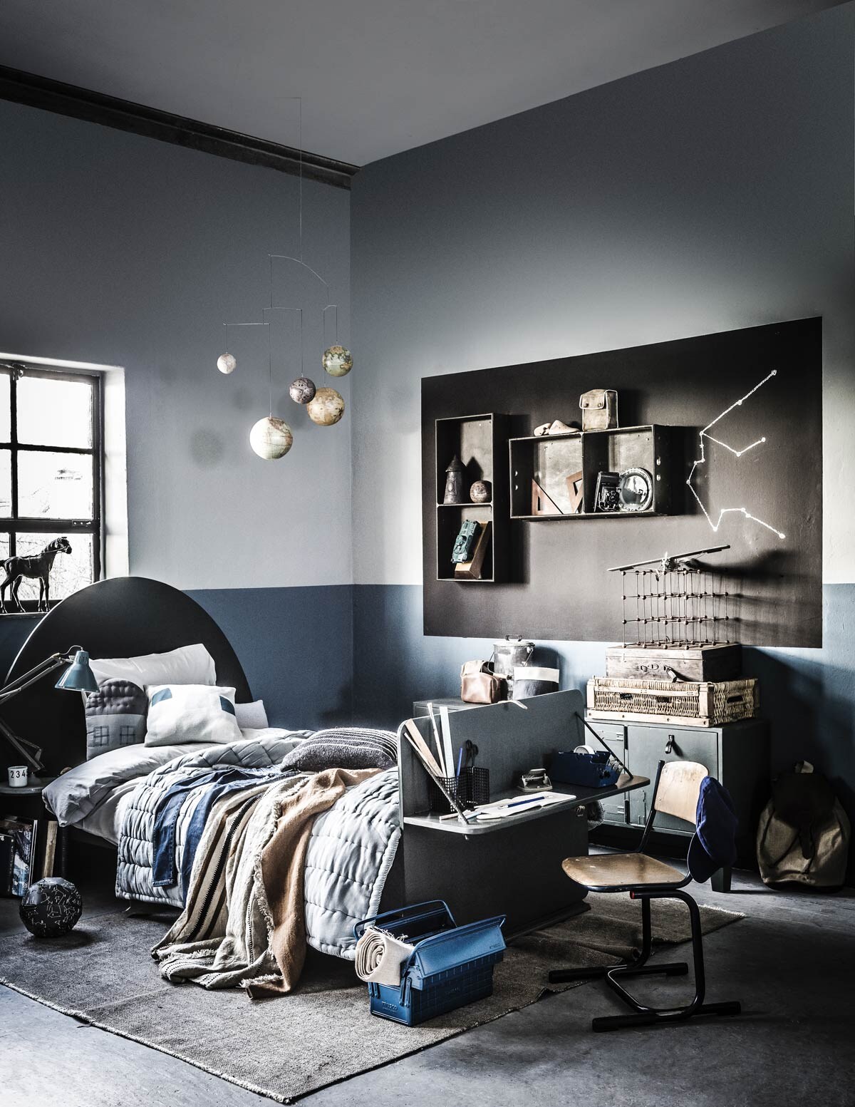 Muurverf Old Blue (onder), Sea Green en Pitch Black van vtwonen (). Paard, liniaal, blauwe pet, stoel (). Bed, houten geodriehoeken, houten voet, kleine groene legertas op muurkistje (). Mobile met wereldbollen van Authentic Models (). Blauwe lamp (). Vloerkleed (). Bruine plaid, tas (). Wereldbol van zwart papier (). Cubes (). Stoffen lappen (). Vliegtuig, gereedschapskist, legertank in onderste muurkistje (). Overig privébezit.