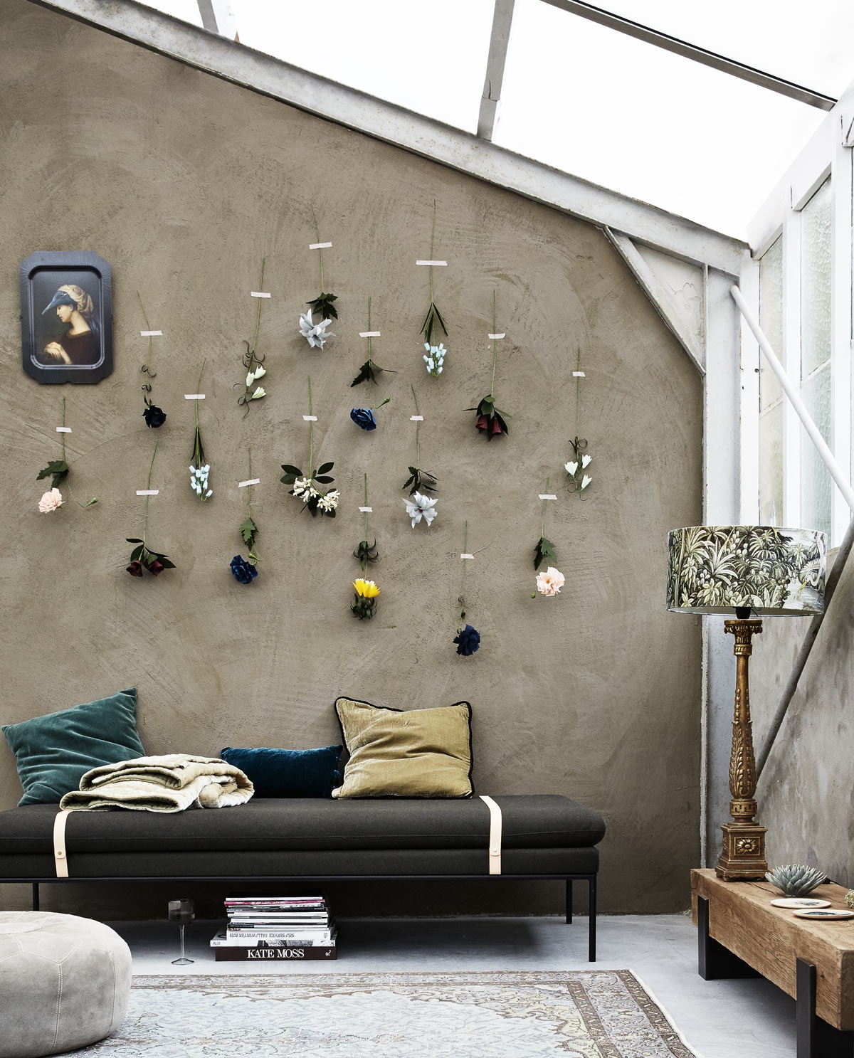 Muurverf kleur Bali (We Are Wow Makers). Papieren bloemen van het Japanse atelier Edenworks (Based on Roots). Dienblad met portret van Ibride (MaisonNL). Daybed van wol, leer en staal van Ferm Living (Kolk en Kolk). Vintage vloerkleed (rozenkelim.nl). Tafel Saam van massief eikenhout en staal (boxworx.nl). Leren poef (Loods 5). Lamp Jungle (HK Living). Keramische bloem, schoteltje (Urban Nature Culture). Groen fluwelen kussen van Madam Stoltz (deens.nl). Fluwelen kussens, plaid (Fabric Copenhagen).