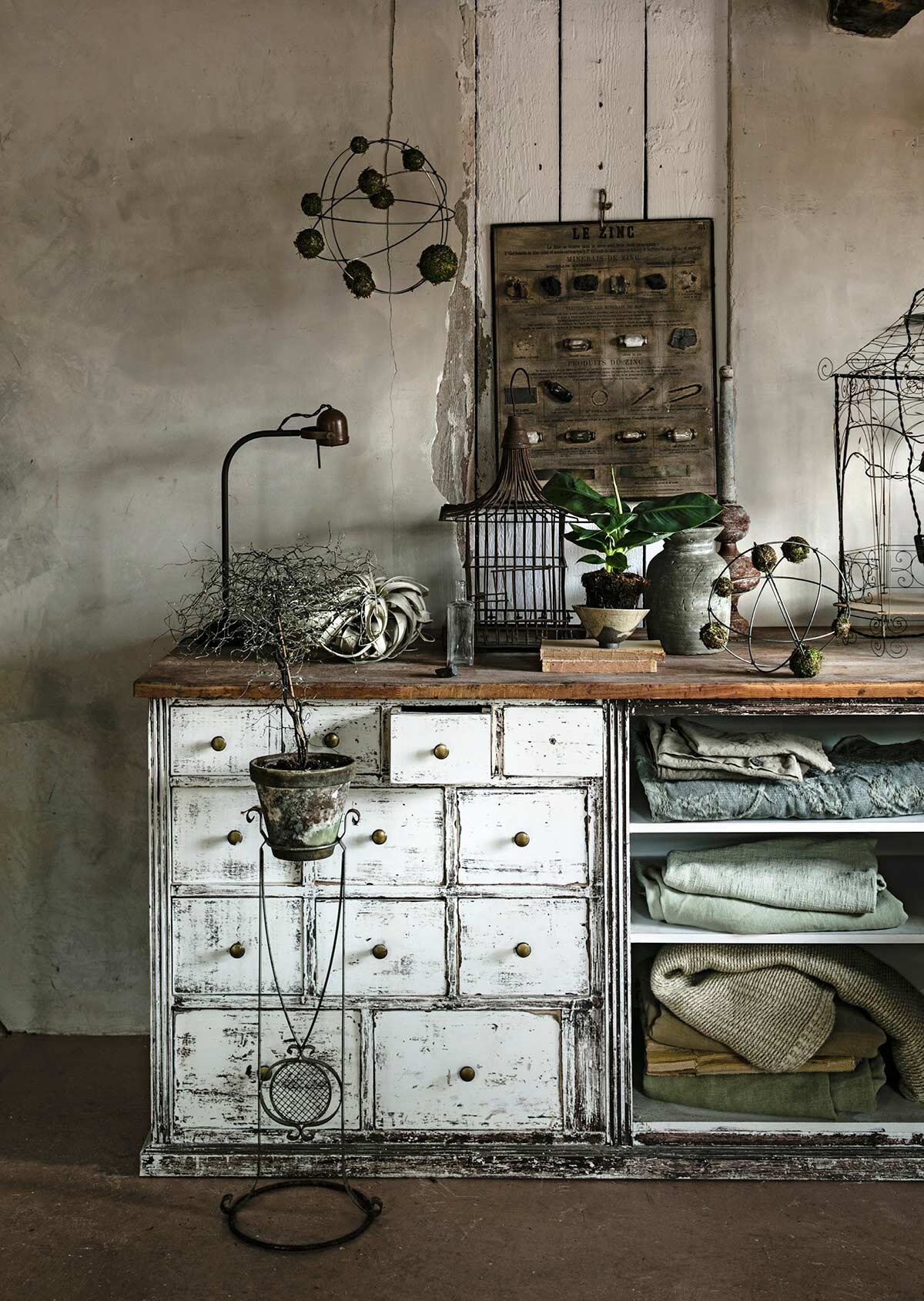 Ballen van draadstaal met bollen van mos (Tuin van Judith). Plantenstandaard (Combitex). Gedroogde Tillandsia (The Wunderkammer). Oude toonbank (Burbri Antiek). Tafellamp, ijzeren kooi met schommelende mensen, plaids in de kast (Meker Wonen). Vogelkooi (Raw Materials). Grijze pot (De Weldaad). Schaaltje voor de plant (Noordermarkt, Amsterdam). Plant (Waterdrinker). Poster (Spoor 38 via Vint. Amersfoort). Metalen ringen (Pipoos). Overig privébezit.
