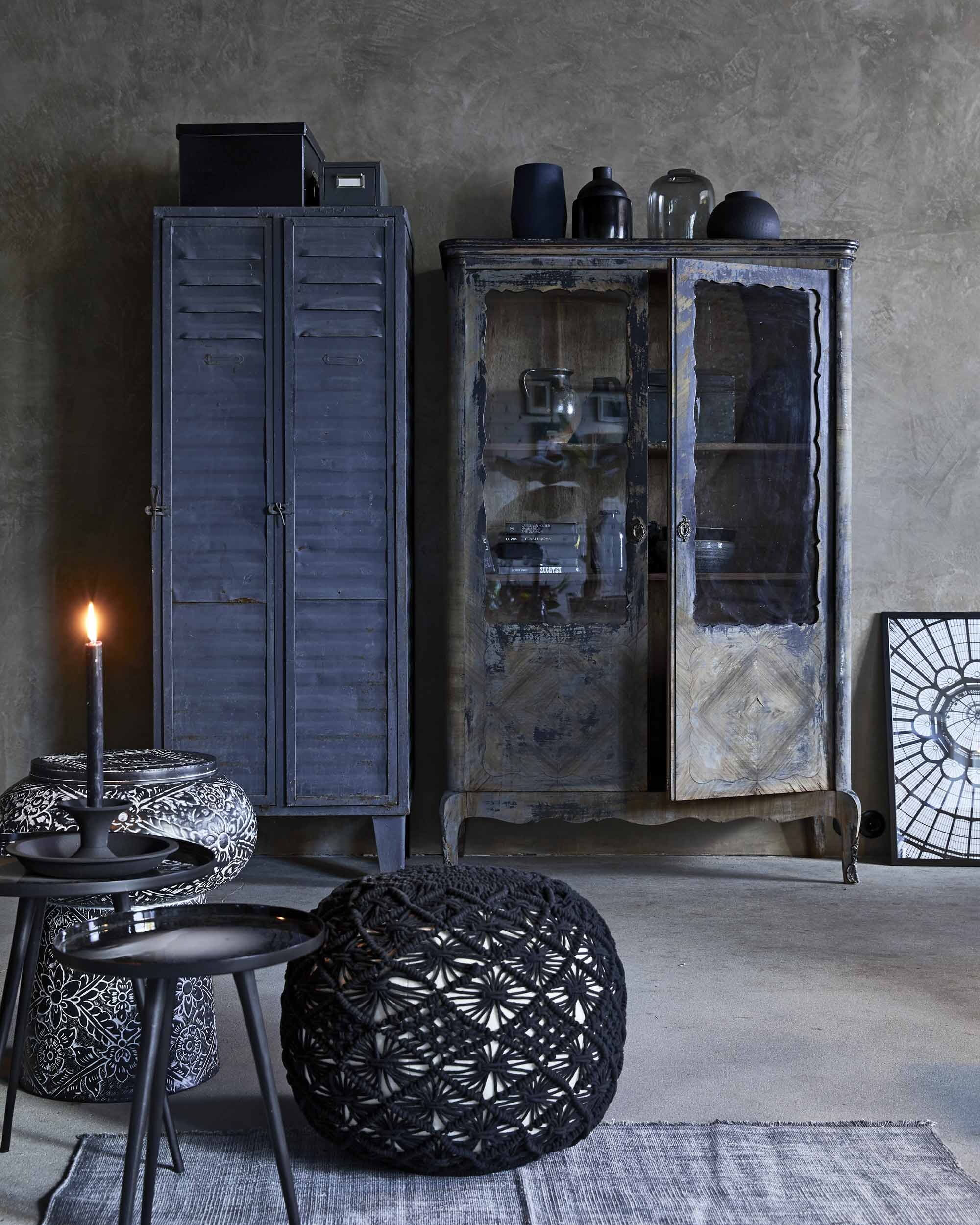 Metalen locker, zwarte houten kast, metalen archiefkastje op locker (Spoor 38). Glazen vaas rechts op kast, gehaakte poef (Loods 5). Zwarte bolle vaas en diepblauwe vaas op de kast (House Doctor). Zwarte vaas, tweede van links op kast (HKliving). Kruik in kast (Van Dijk &amp; Ko). Driepoot tafeltjes, set van 2 (Zuiver). Kandelaar (vtwonen.nl). Gedecoreerde metalen bijzettafel/kruk (Dutchbone). Vloerkleed (vtwonen.nl). Posters van dakkoepel (The Poster Club). Lijst (IKEA).