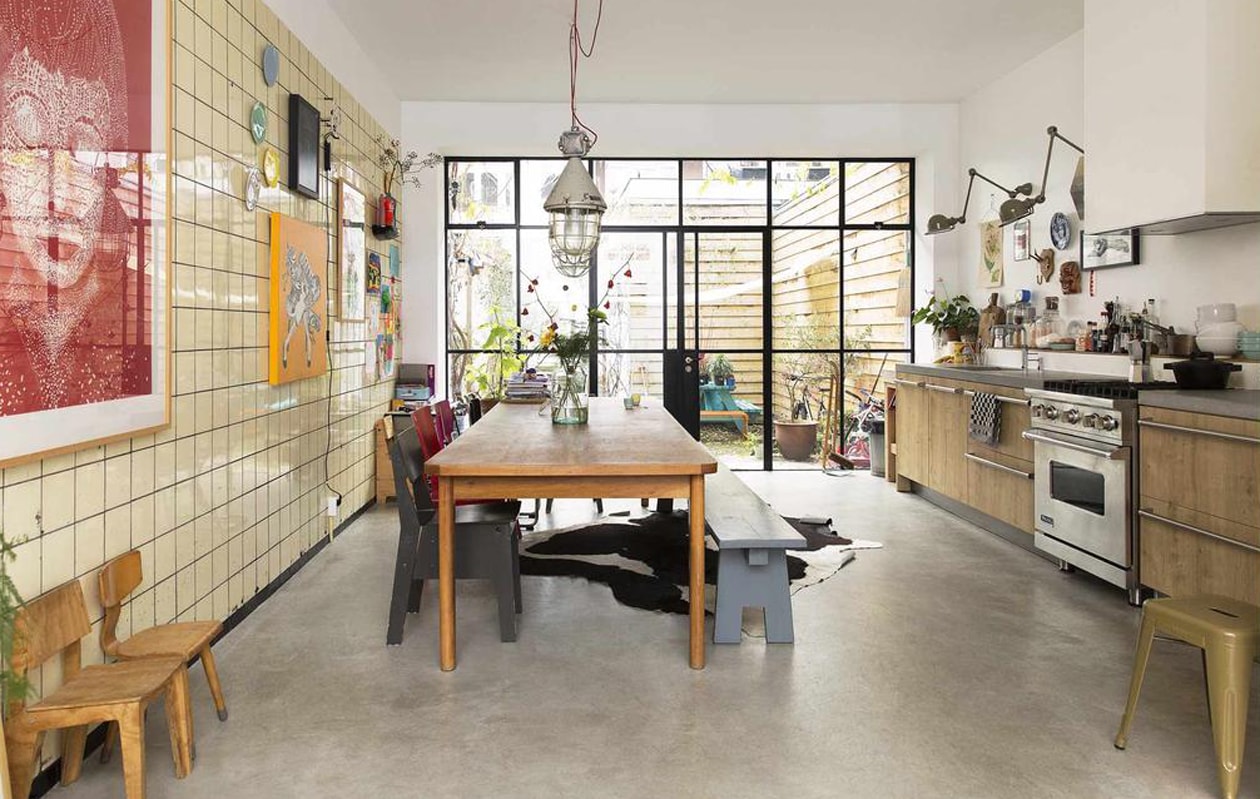 De keuken van Siematic, met een gasfornuis van Viking, geeft door de houten look een warme uitstraling bij de wat killere betonvloer. Ook op het aanrecht mag alles worden gezien. Muurlampen van Jieldé, prullenbak van de rommelmarkt. Kruk van Tolix. vtwonen binnenkijken special 121-2017 | styling Emmy van Dantzig | fotografie Jansje Klazinga